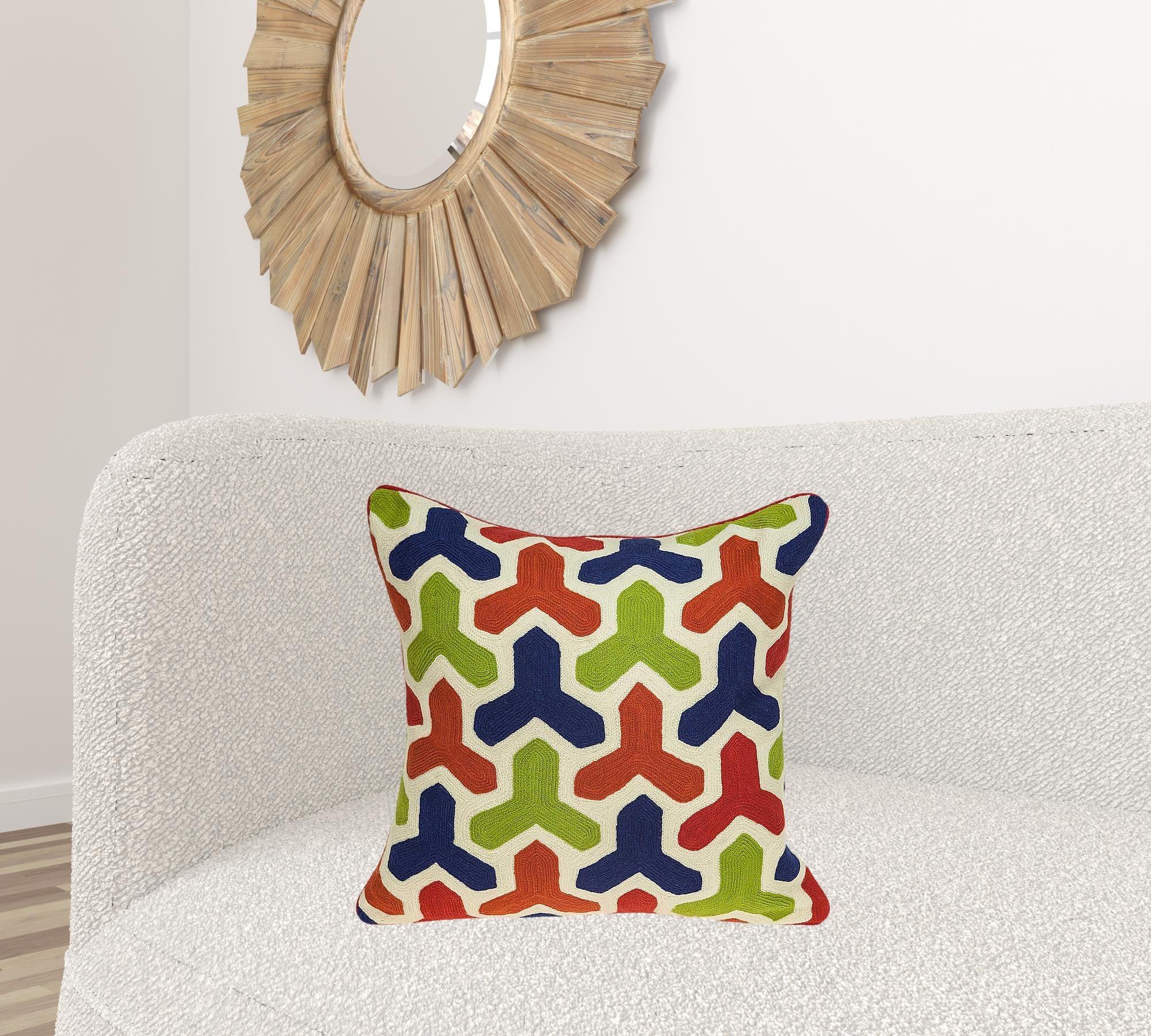 Handmade transitional pillow cover in red and blue, showcasing a multicolored knitted design, perfect for home decor.