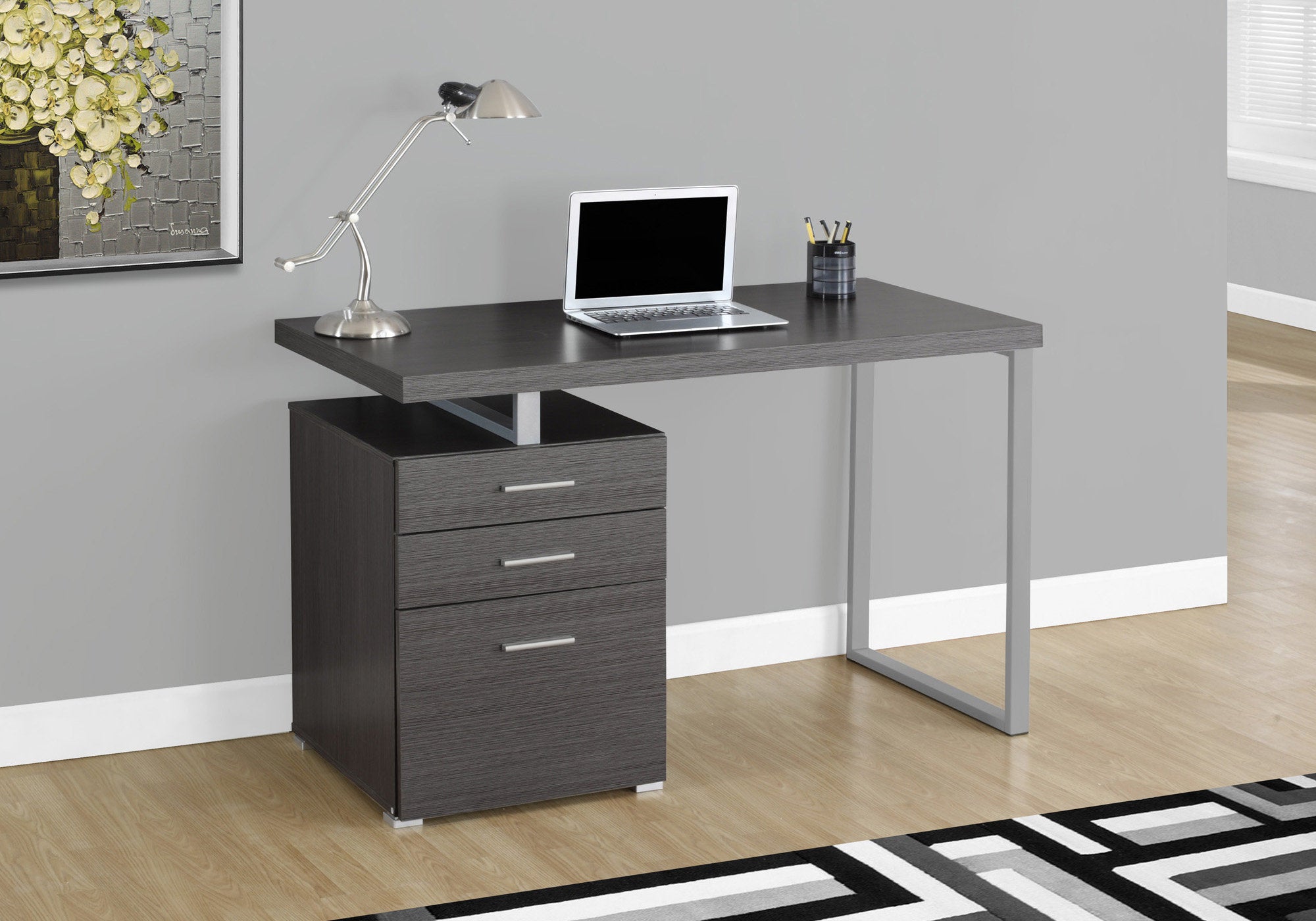 A modern white and silver particle board computer desk with three drawers, showcasing a sleek design suitable for home or office use.