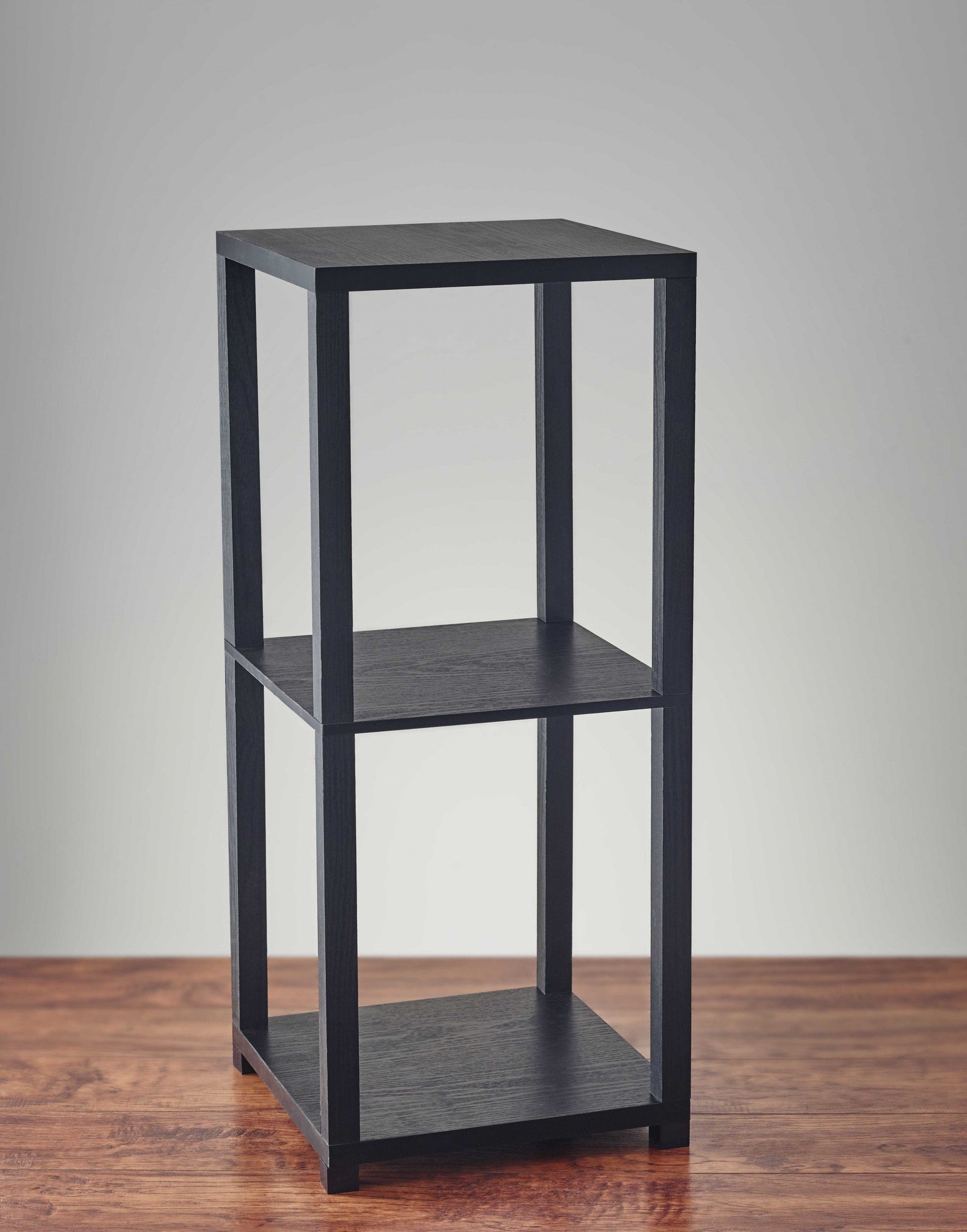 28 inches high black book case end table with three horizontal surfaces for storage and display, featuring a minimalist design.