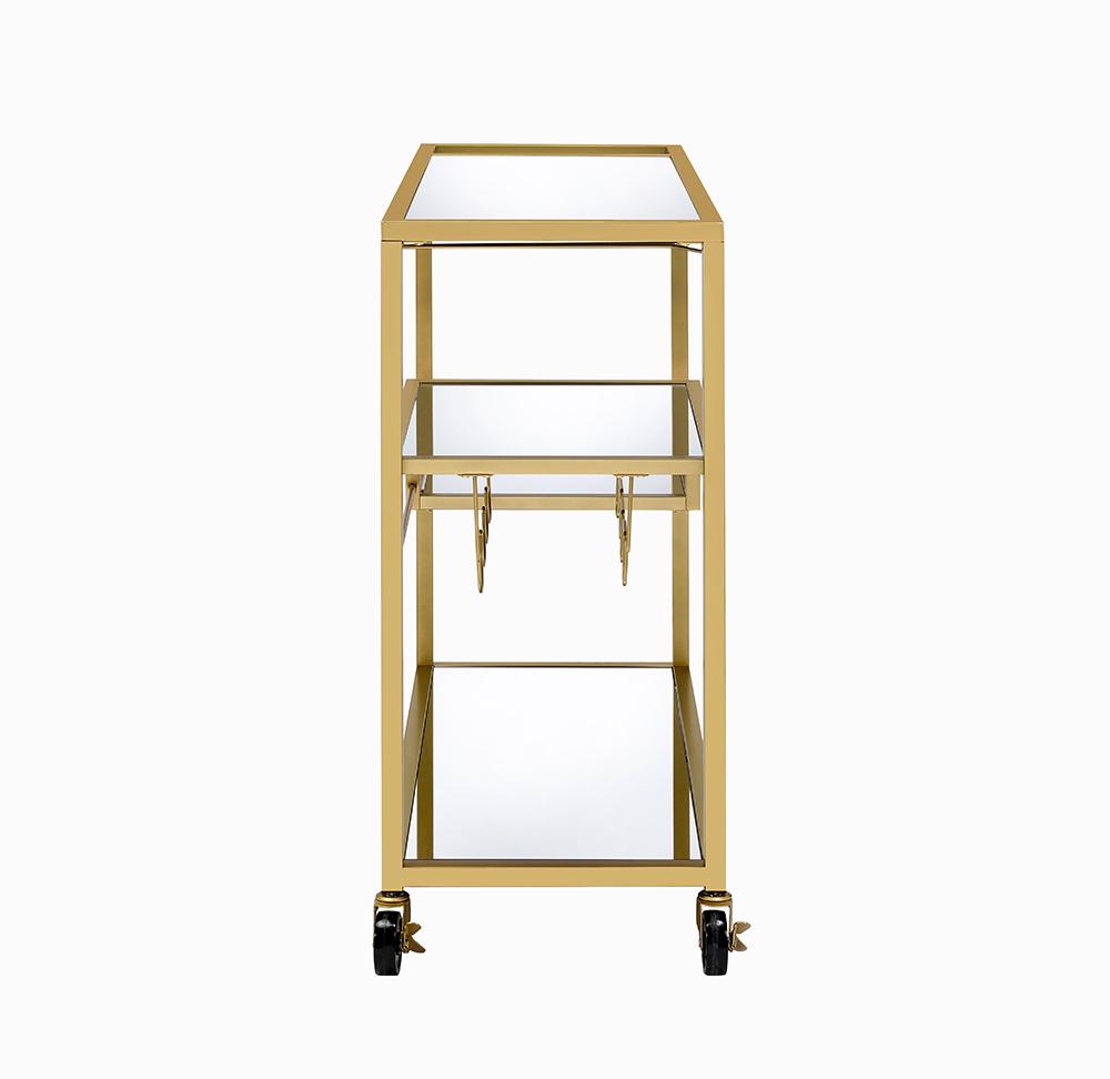 Elegant gold and clear glass serving cart with three shelves and caster wheels, perfect for serving meals and drinks.