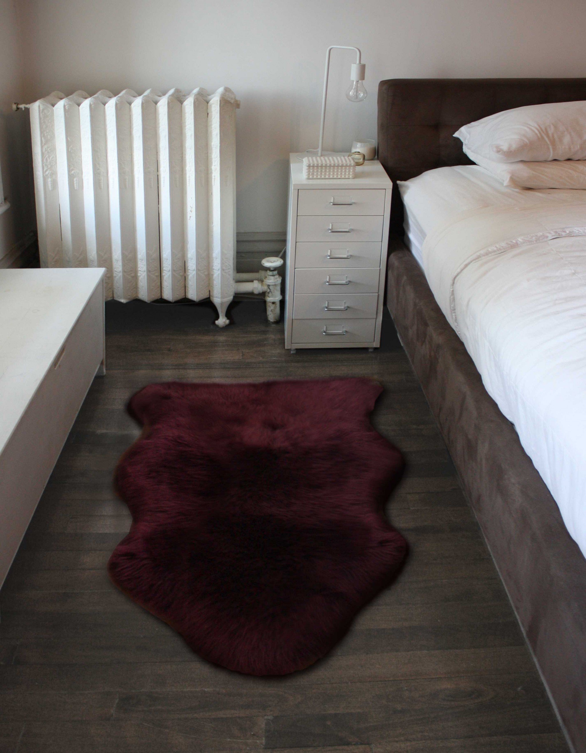 A luxurious 2x3 burgundy New Zealand natural sheepskin rug showcasing its rich texture and color, perfect for home decor.