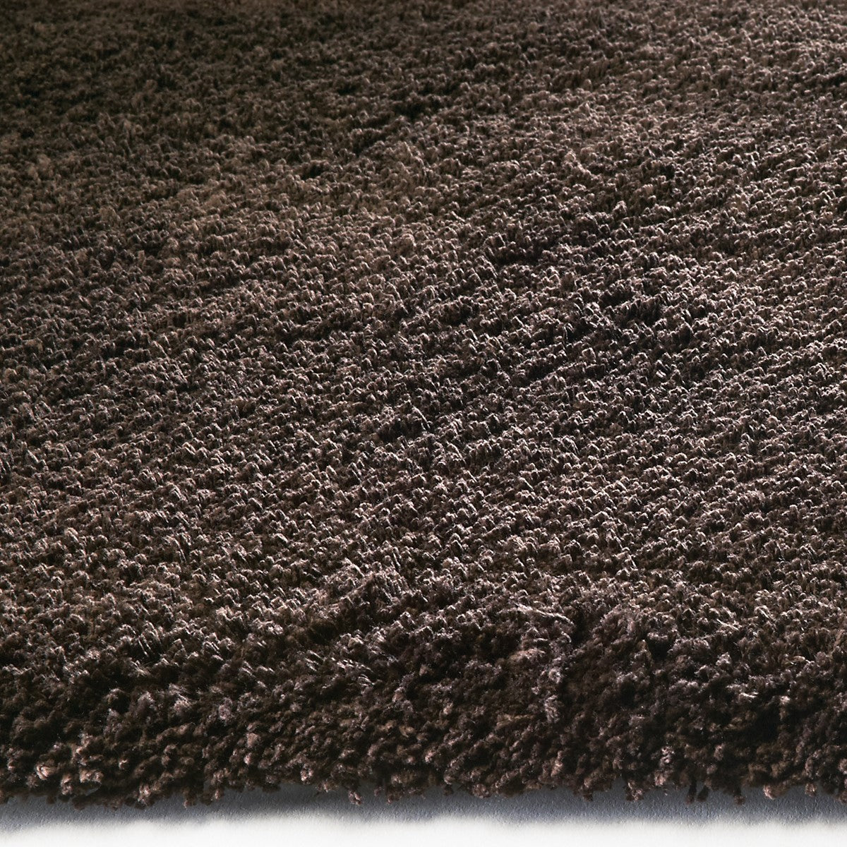 A luxurious 2x4 espresso brown indoor shag rug, showcasing its soft texture and rich color, perfect for enhancing home decor.