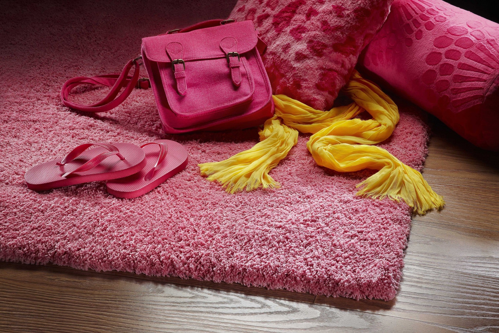 A vibrant hot pink indoor shag rug, hand woven with high-grade polyester and cotton backing, perfect for adding color and comfort to any room.