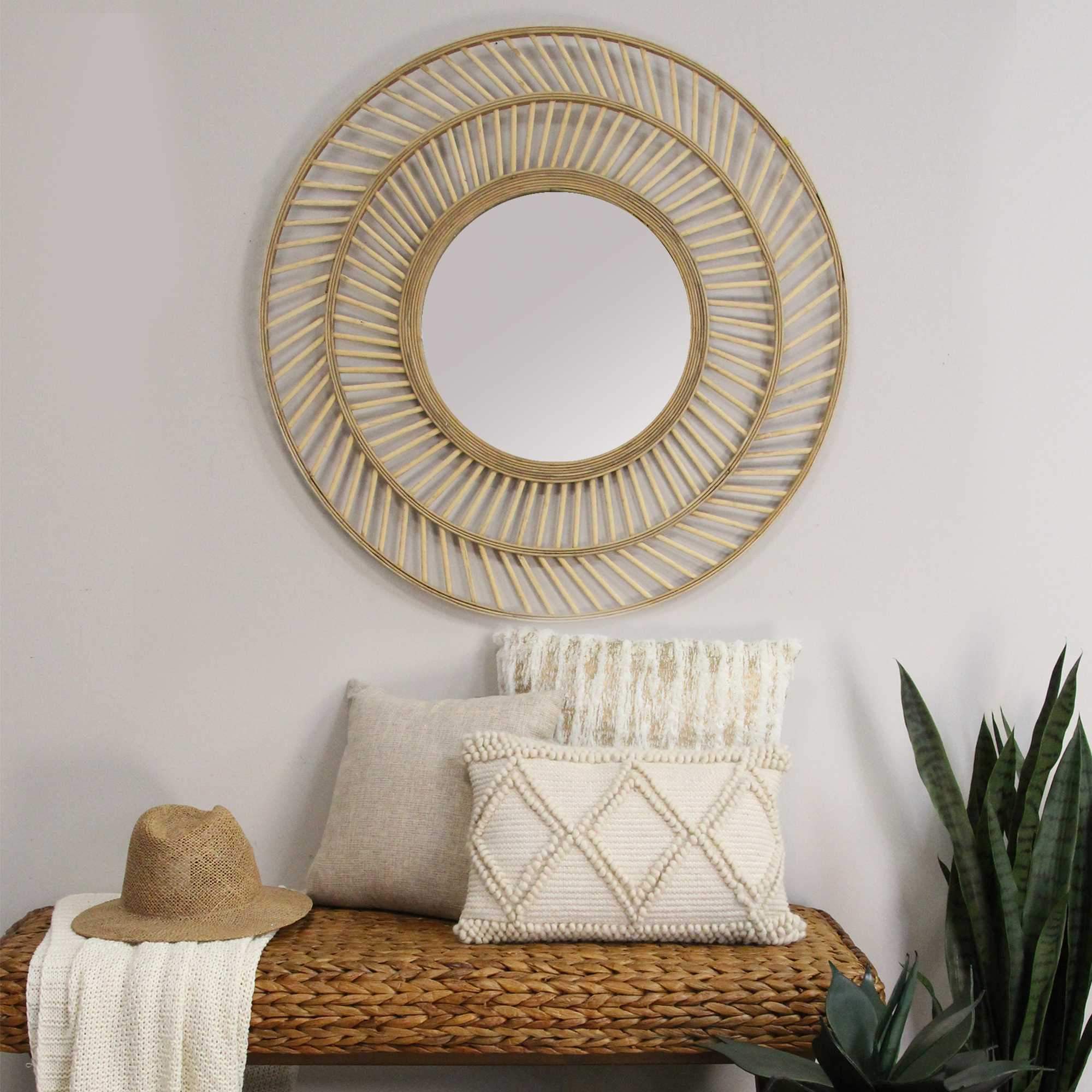 A 31.5-inch round boho casual woven wicker wall mirror with a natural rattan frame and intricate cutout patterns, enhancing home decor.