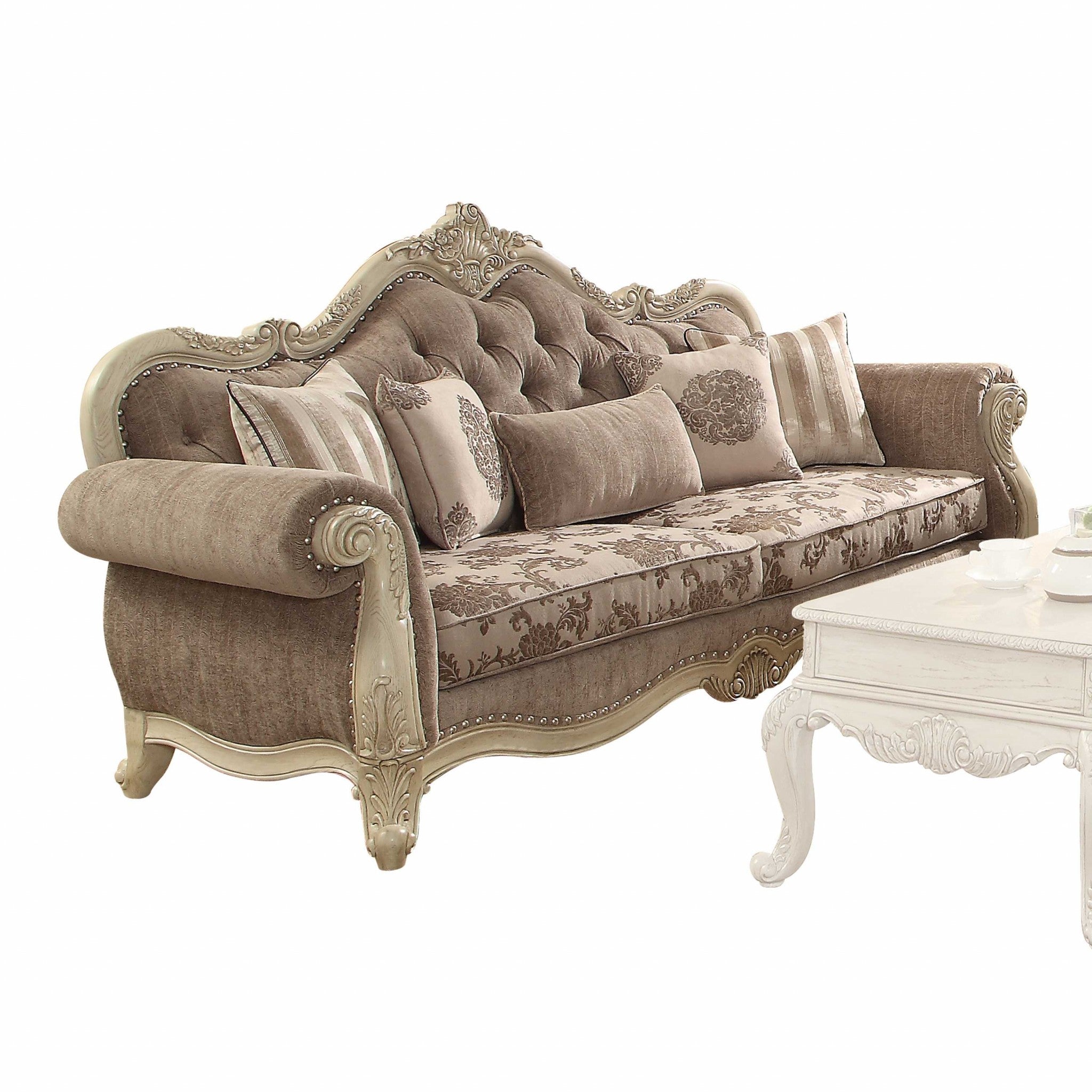 A luxurious vintage oak upholstery sofa with decorative pillows, featuring a button tufted backrest and elegant scrollwork trim.