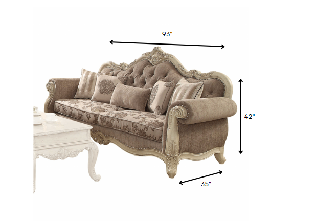 A luxurious vintage oak upholstery sofa with decorative pillows, featuring a button tufted backrest and elegant scrollwork trim.