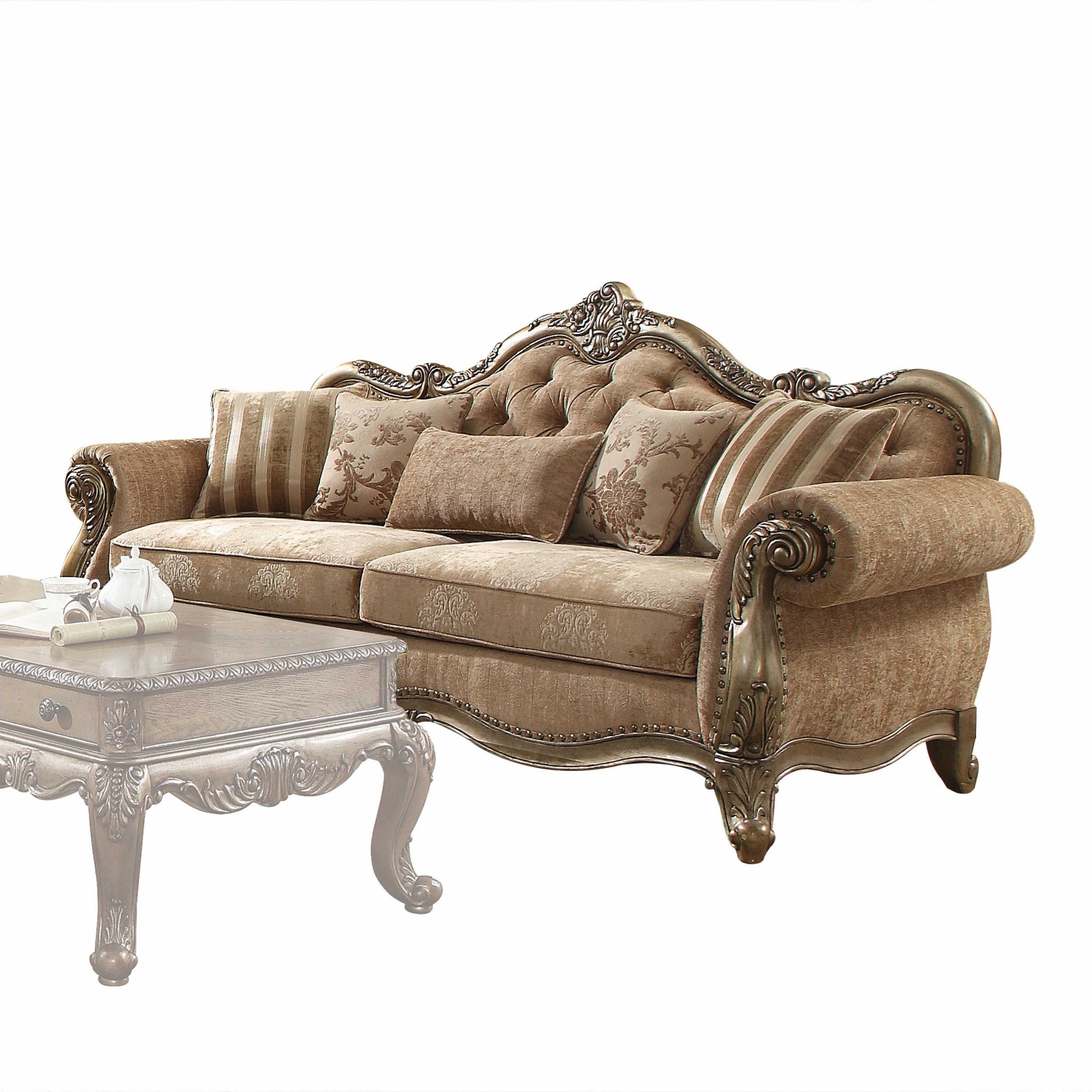 A luxurious vintage oak upholstery sofa with decorative pillows, featuring a button tufted backrest and elegant scrollwork trim.