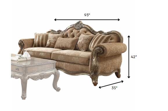 A luxurious vintage oak upholstery sofa with decorative pillows, featuring a button tufted backrest and elegant scrollwork trim.