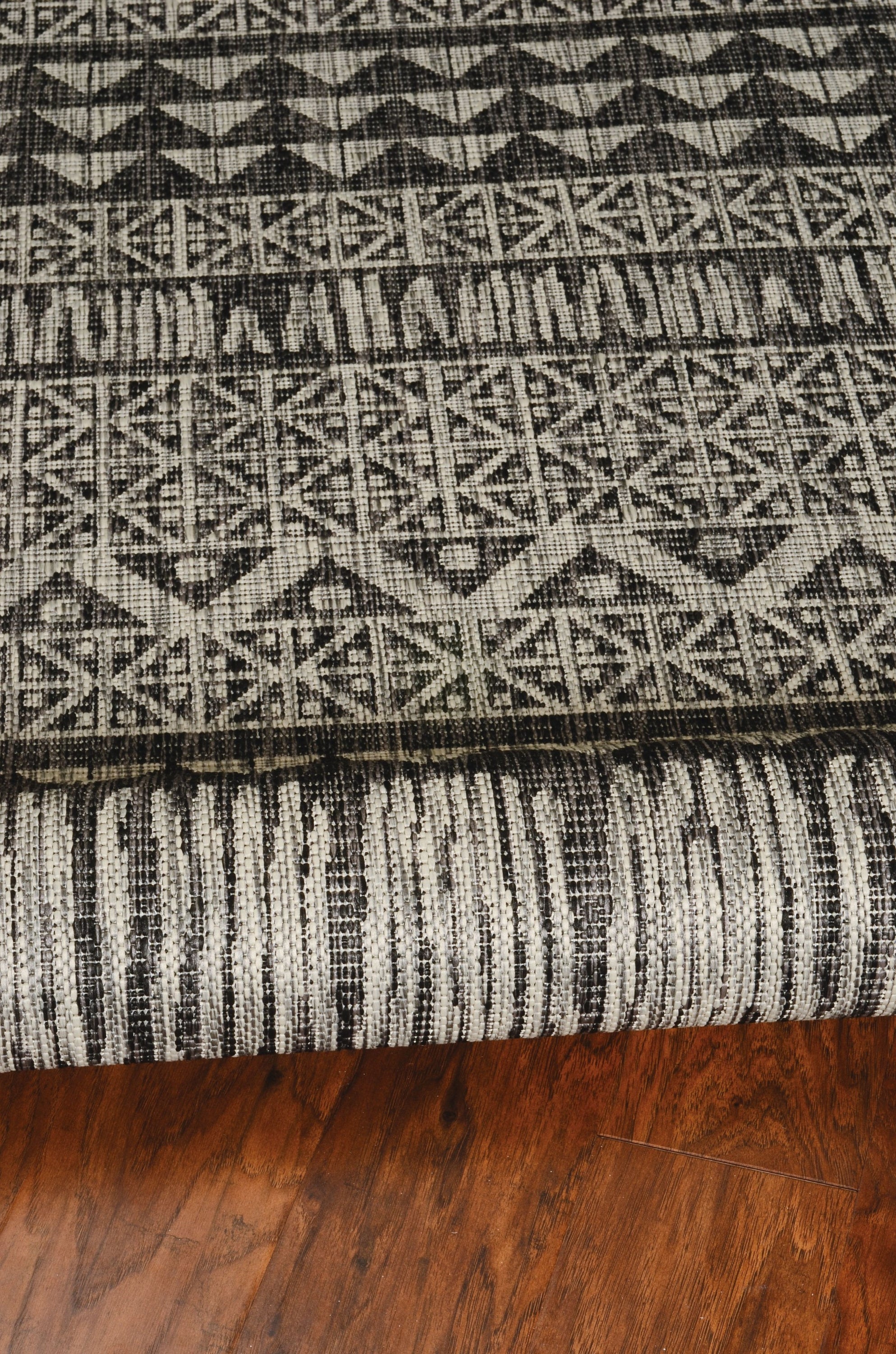 3x4 charcoal tribal indoor/outdoor rug with vibrant patterns, machine-woven in Turkey, suitable for various decor styles.