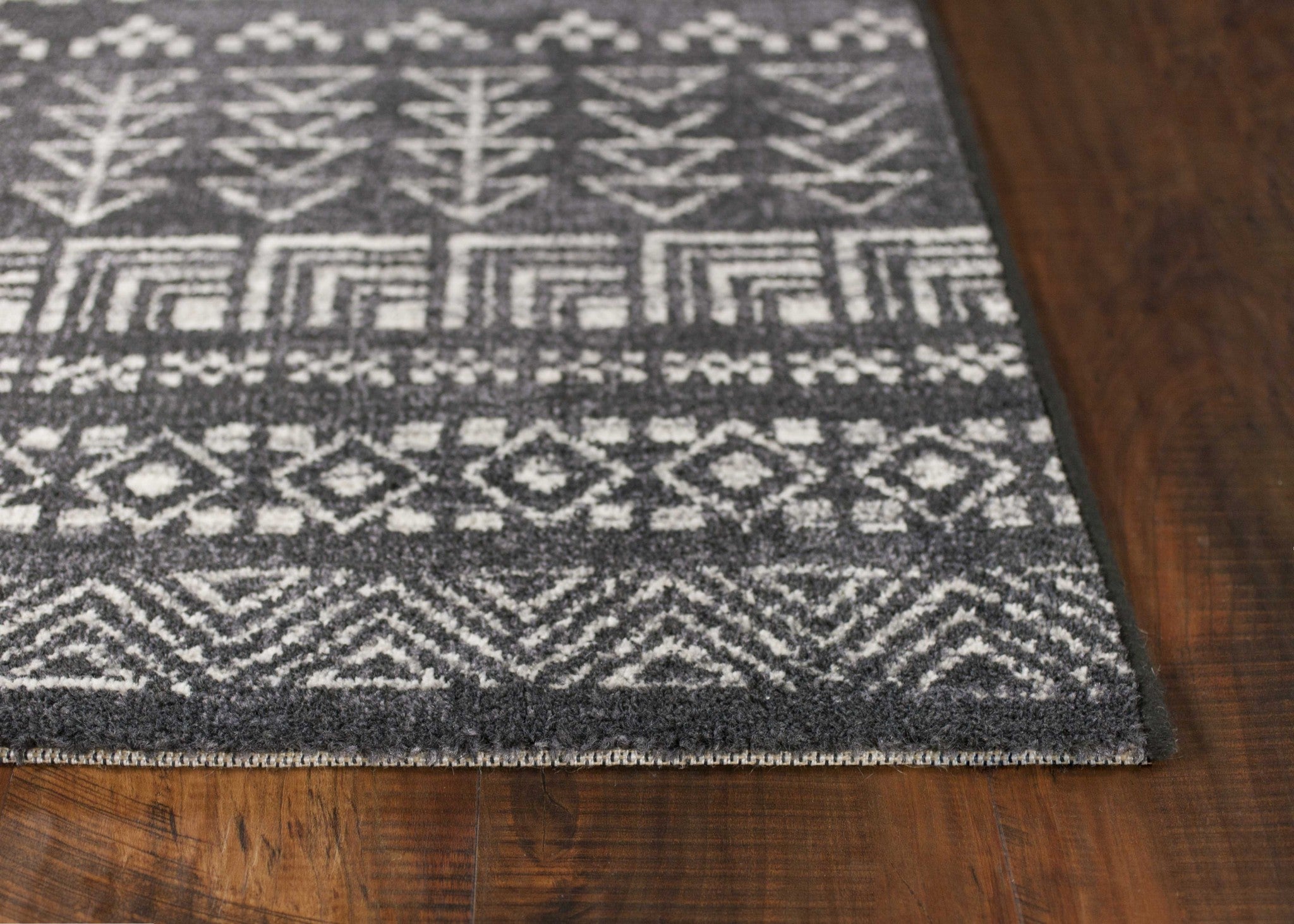 A stylish charcoal grey machine woven bohemian tribal indoor rug, showcasing intricate patterns and a soft texture, perfect for enhancing home decor.