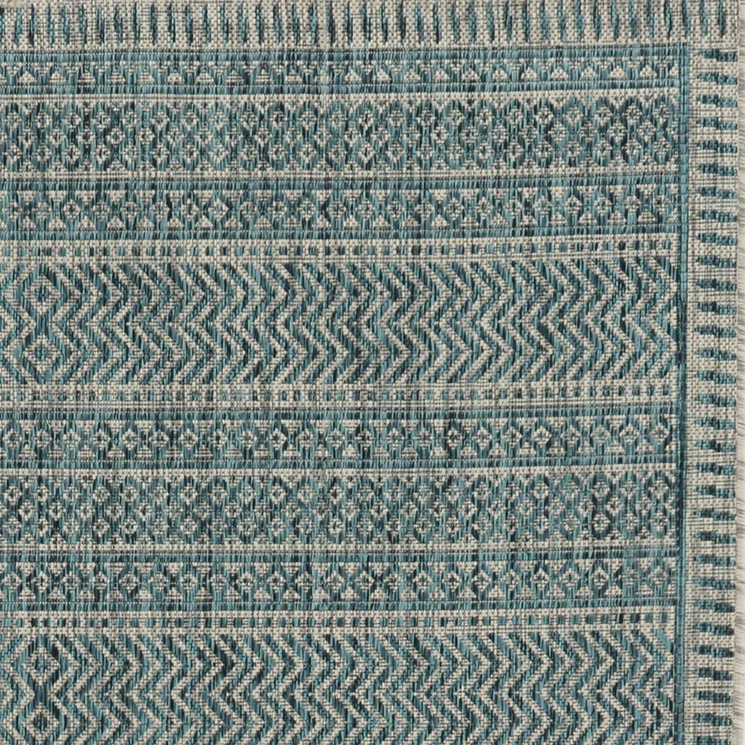 Teal tribal indoor outdoor rug, machine woven, UV treated, showcasing vibrant colors and patterns, perfect for enhancing any space.