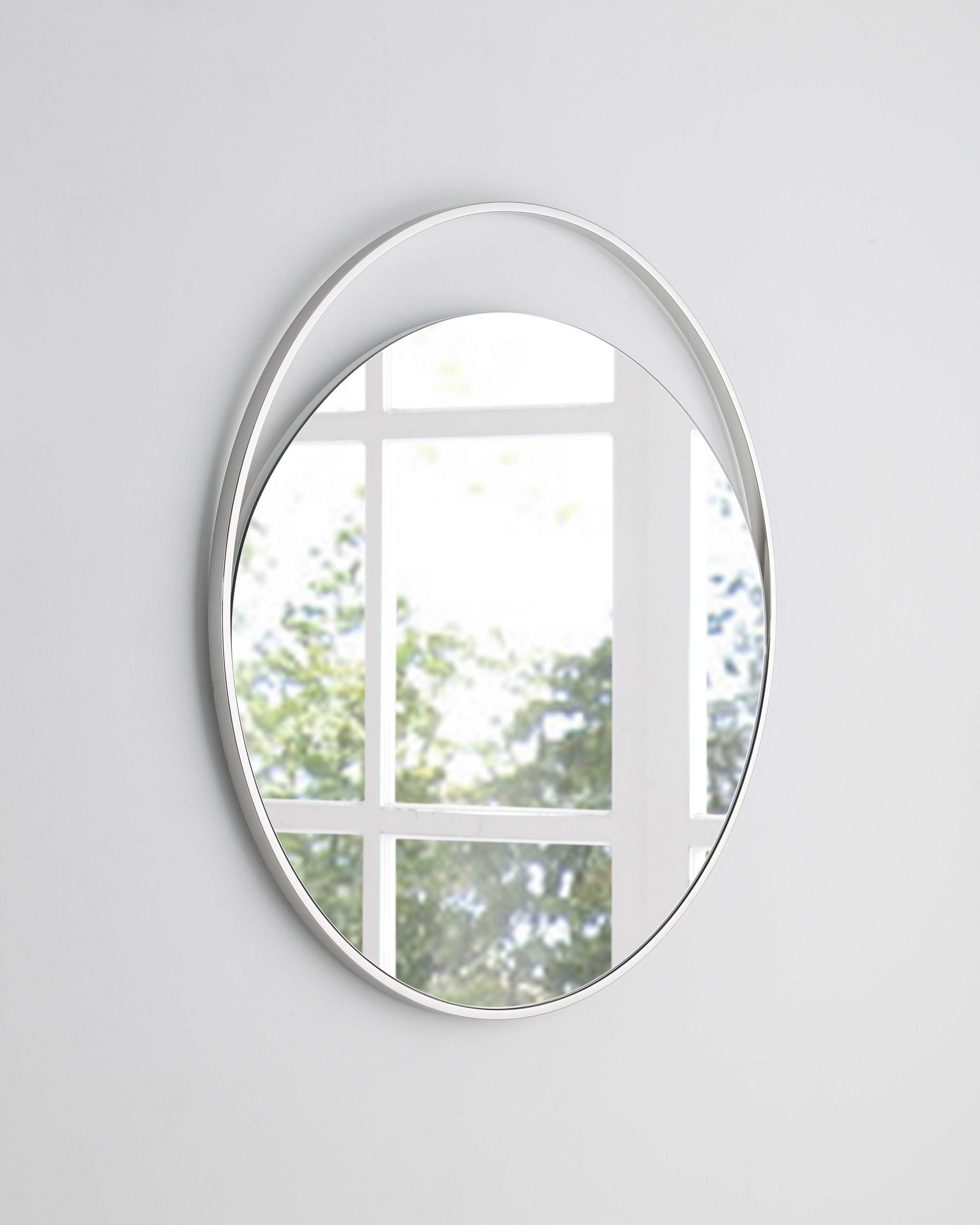 A large round mirror with a white matte finish, measuring 40 inches in diameter, elegantly displayed against a stylish wall.