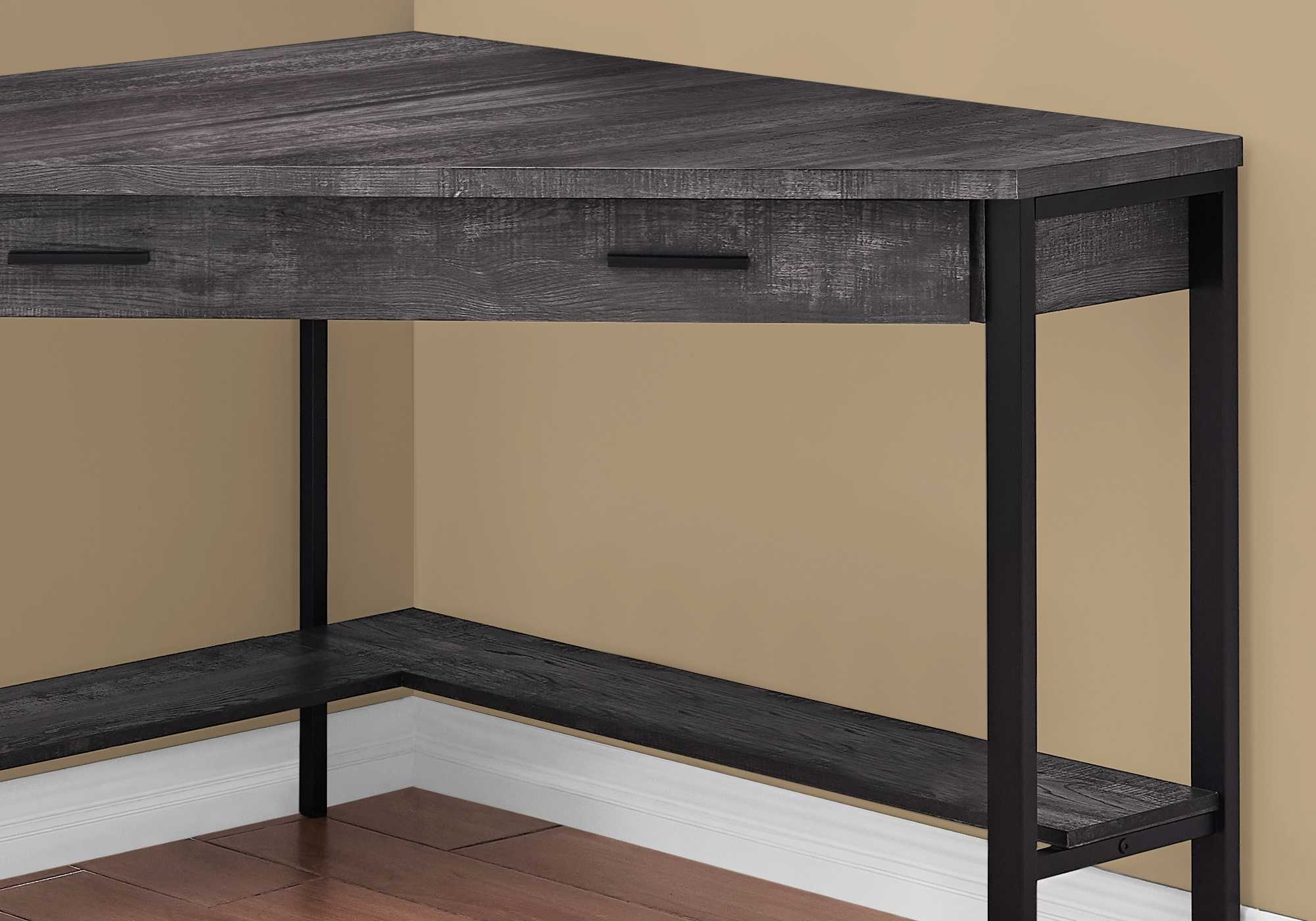 A stylish black reclaimed wood corner computer desk with a long drawer, designed for small spaces.