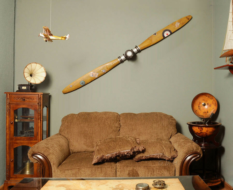 A vintage-style wooden airplane propeller measuring 4.5 inches by 79 inches by 10 inches, featuring brass accents and intricate designs, perfect for decor.