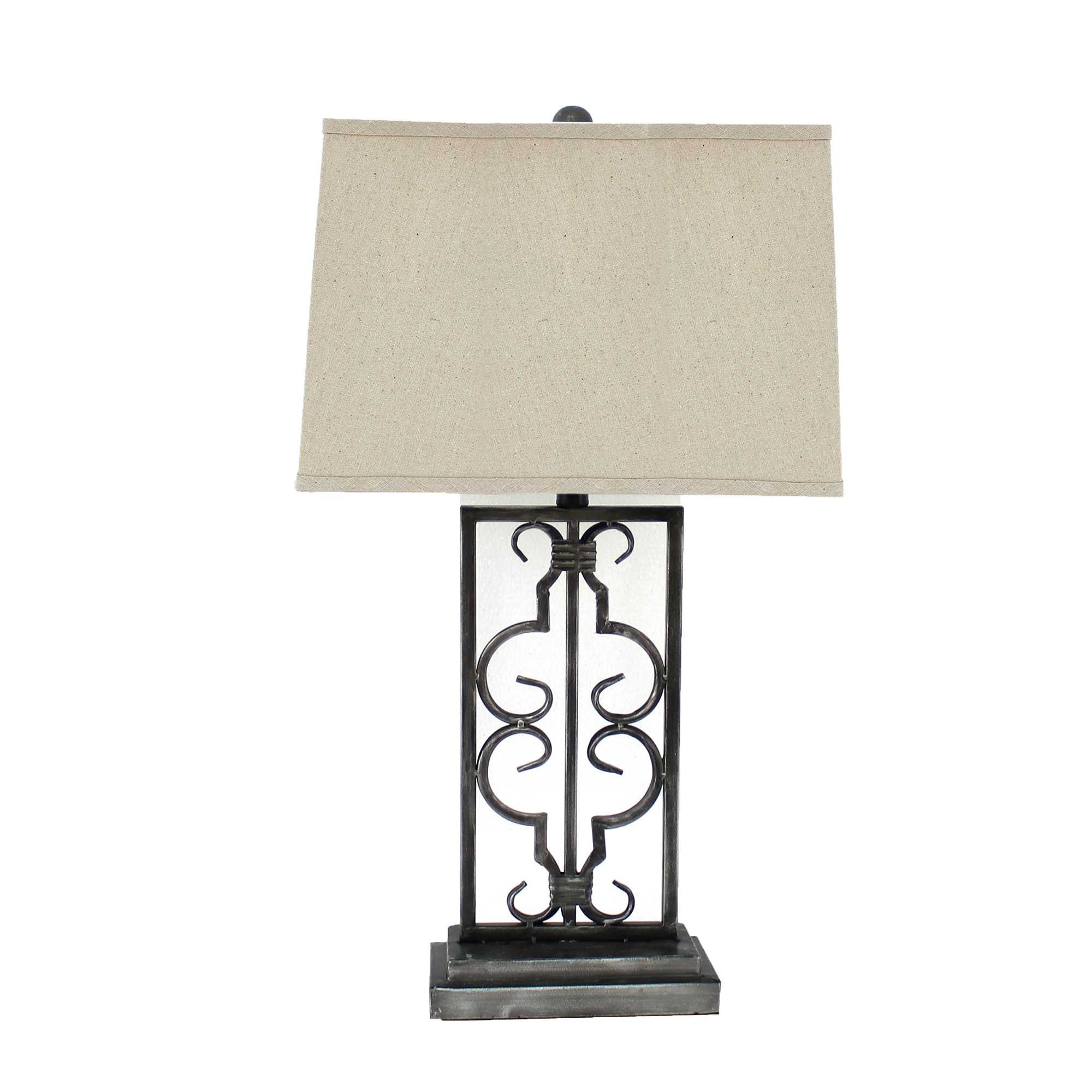 Gray industrial table lamp with stacked metal pedestal and beige linen shade, illuminating a stylish living space.