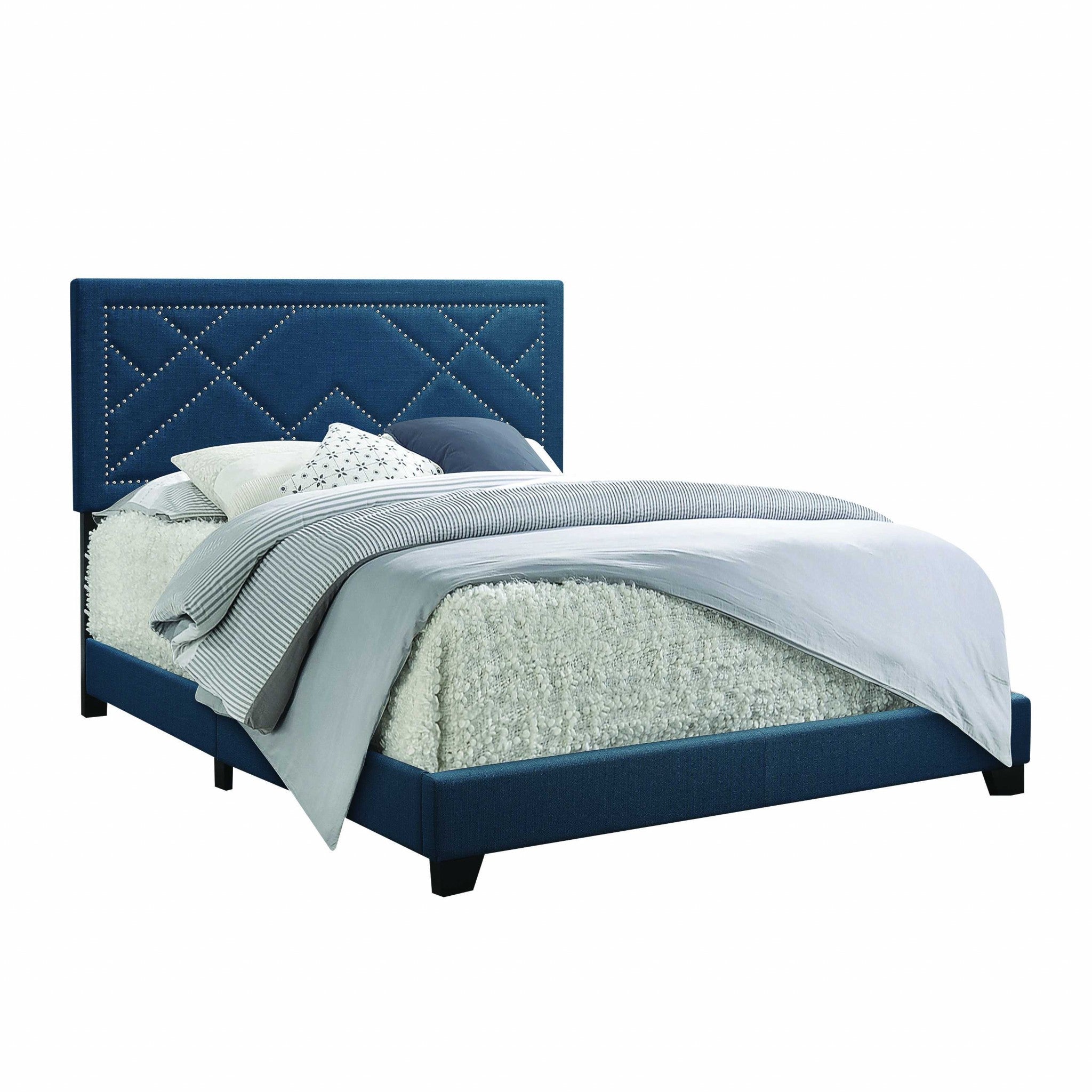 A dark teal fabric upholstered bed featuring a padded headboard with chrome nailhead trim and a low-profile footboard, set in a stylish bedroom.