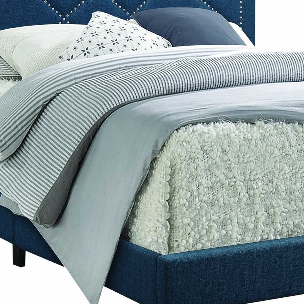 A dark teal fabric upholstered bed featuring a padded headboard with chrome nailhead trim and a low-profile footboard, set in a stylish bedroom.