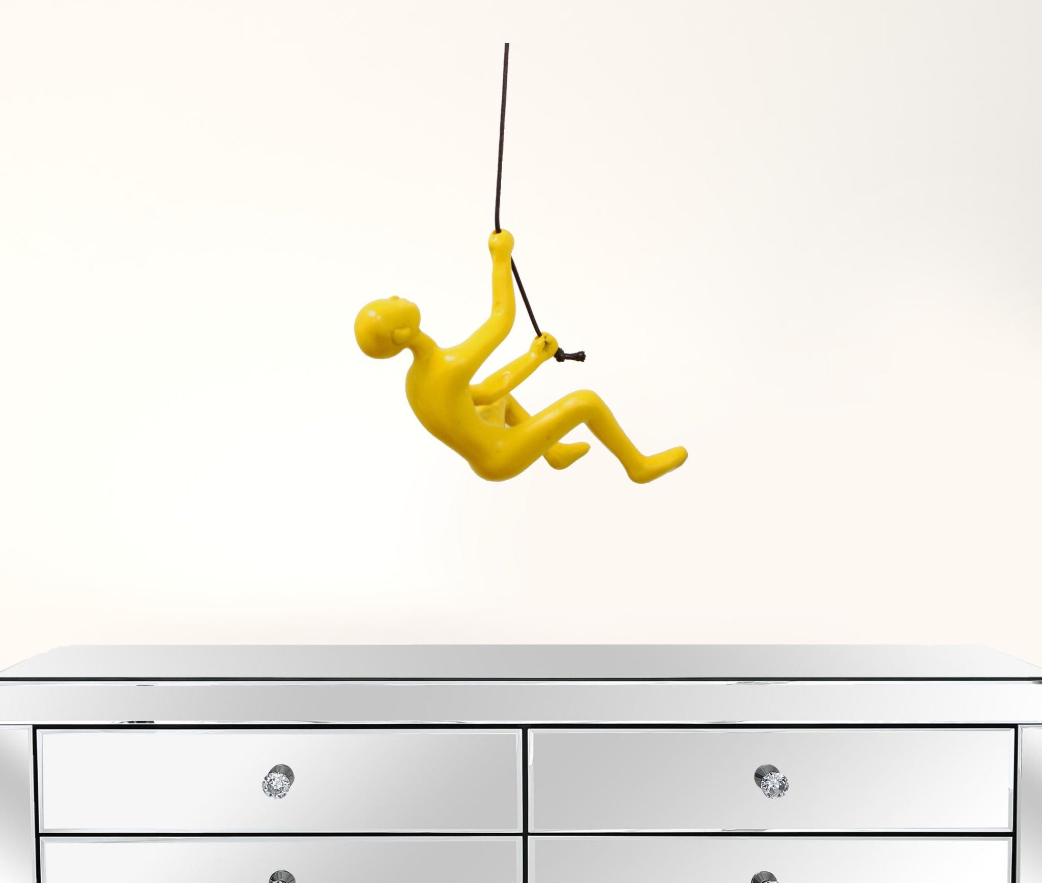 A vibrant yellow resin sculpture of a man climbing, designed for wall art decoration, showcasing a modern and unique aesthetic.