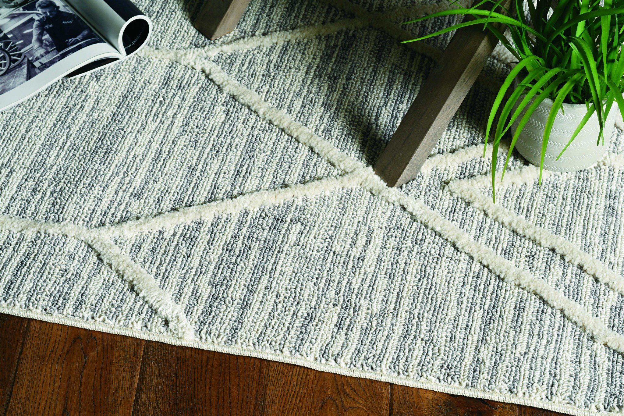 A hand-woven grey wool and jute rug measuring 78 x 114 inches, showcasing a textured surface and cotton backing, perfect for contemporary living spaces.