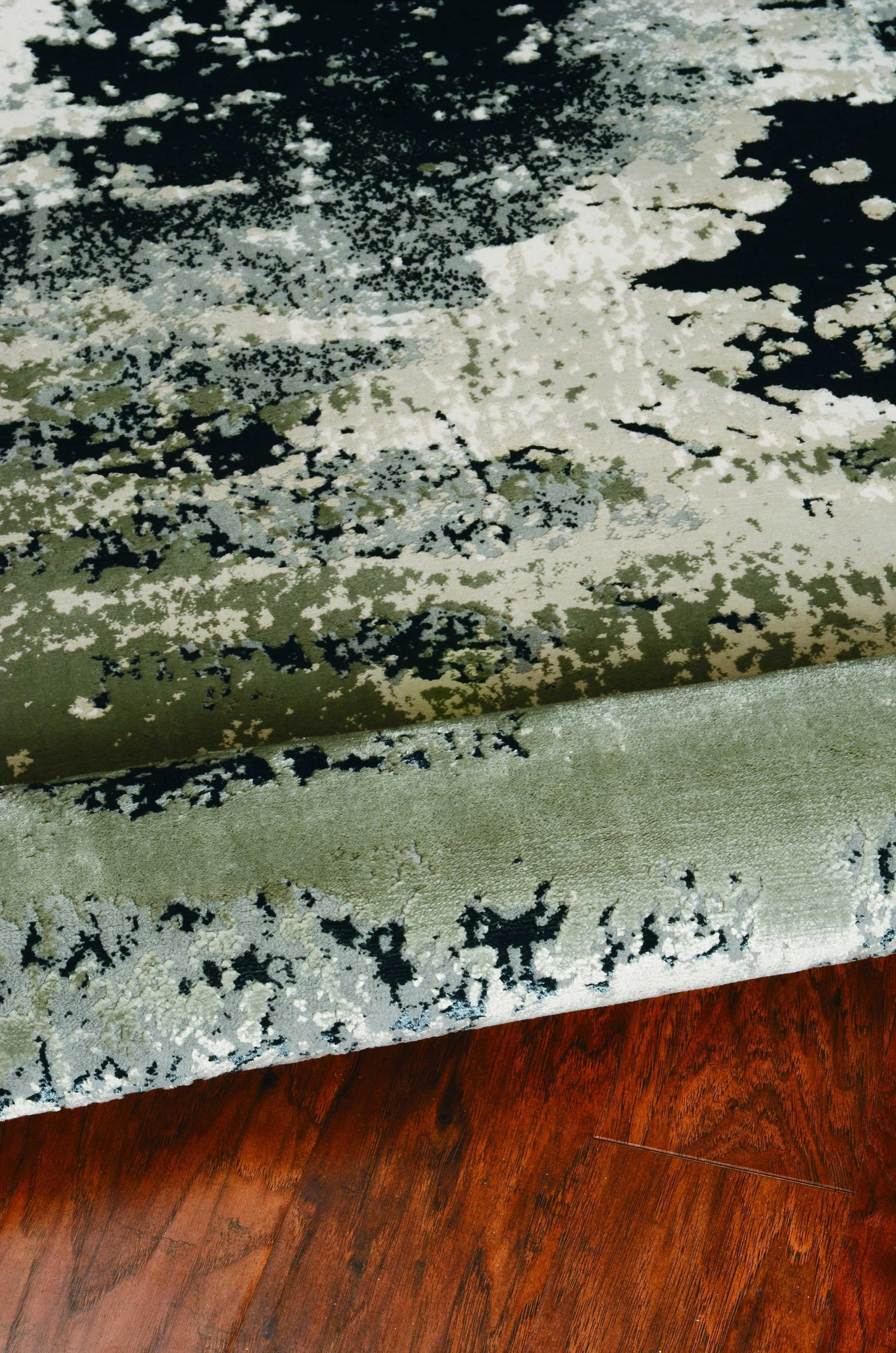 A stylish 7x10 inches polyester silver charcoal area rug featuring modern paint-dripping effects and layered designs, perfect for contemporary decor.