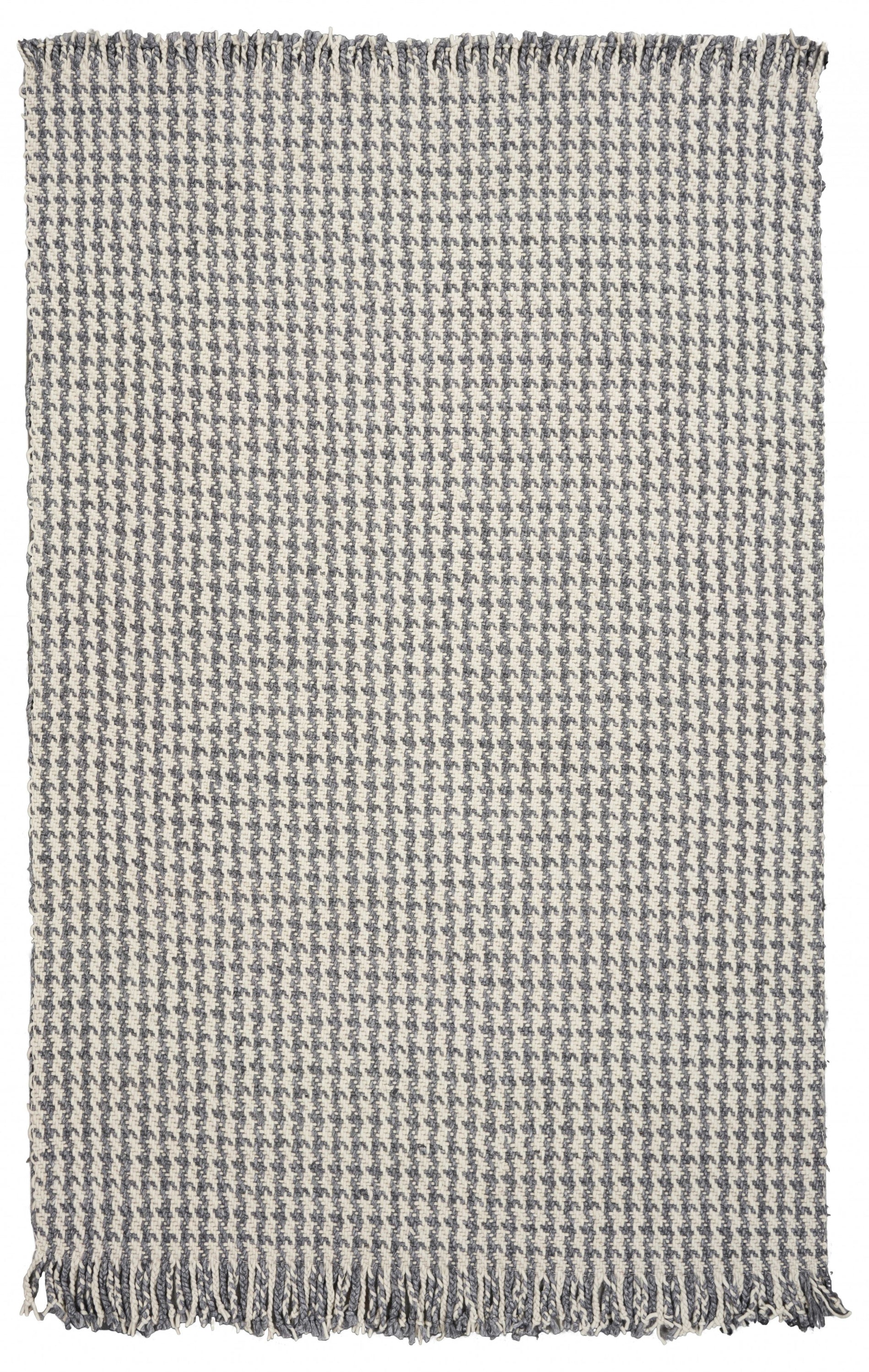 A luxurious 7x9 inches wool area rug in ivory and grey houndstooth pattern, featuring braided fringe for a modern touch.