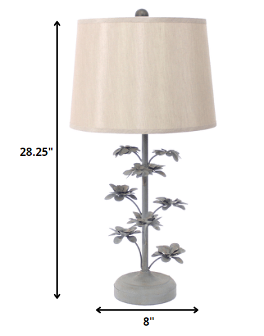 Gray rustic flowering tree table lamp with beige linen shade, showcasing a unique metal base design.