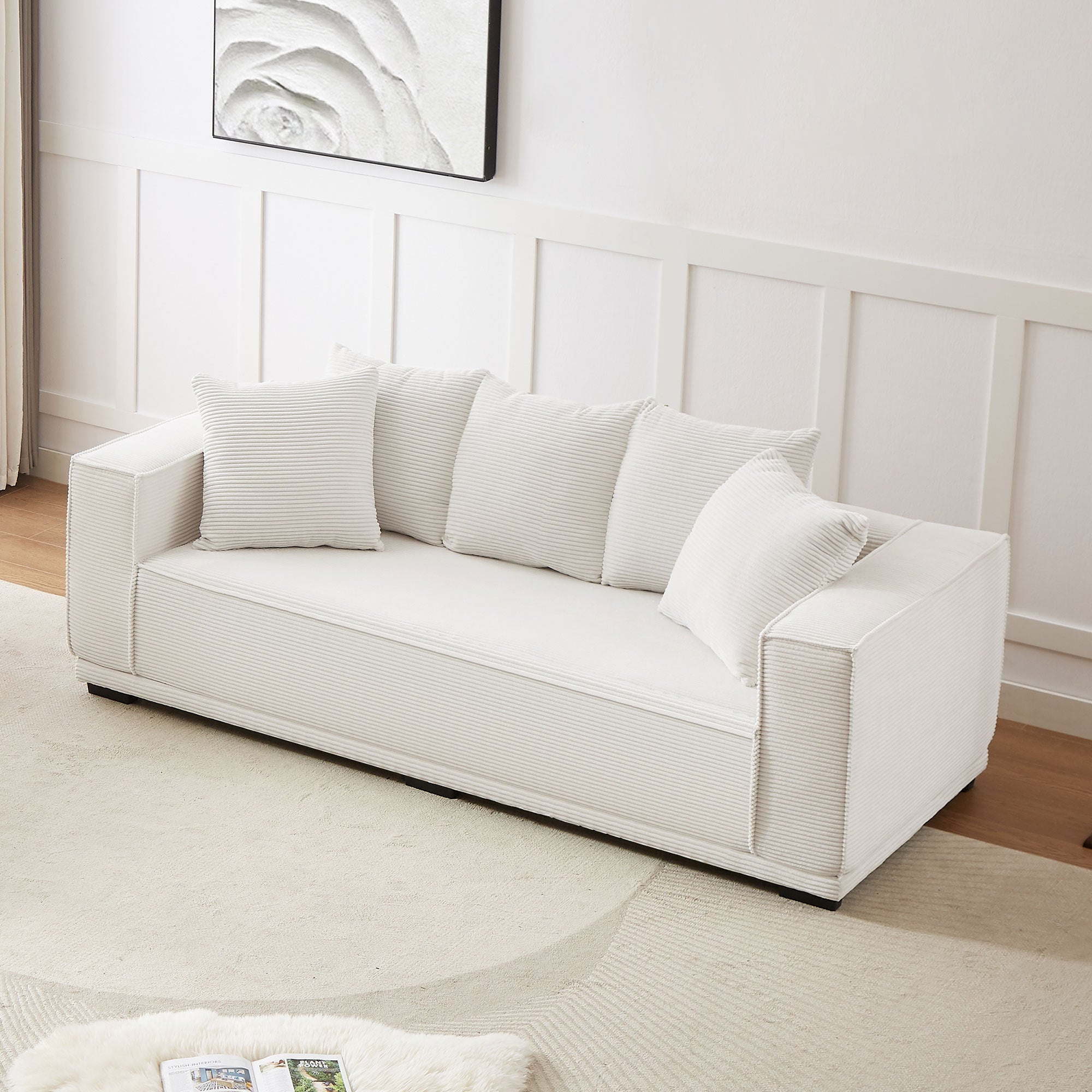 A stylish 88.97'' Mid Century Modern Upholstered Sofa in white corduroy, featuring a sleek design and five matching toss pillows, perfect for modern living rooms.