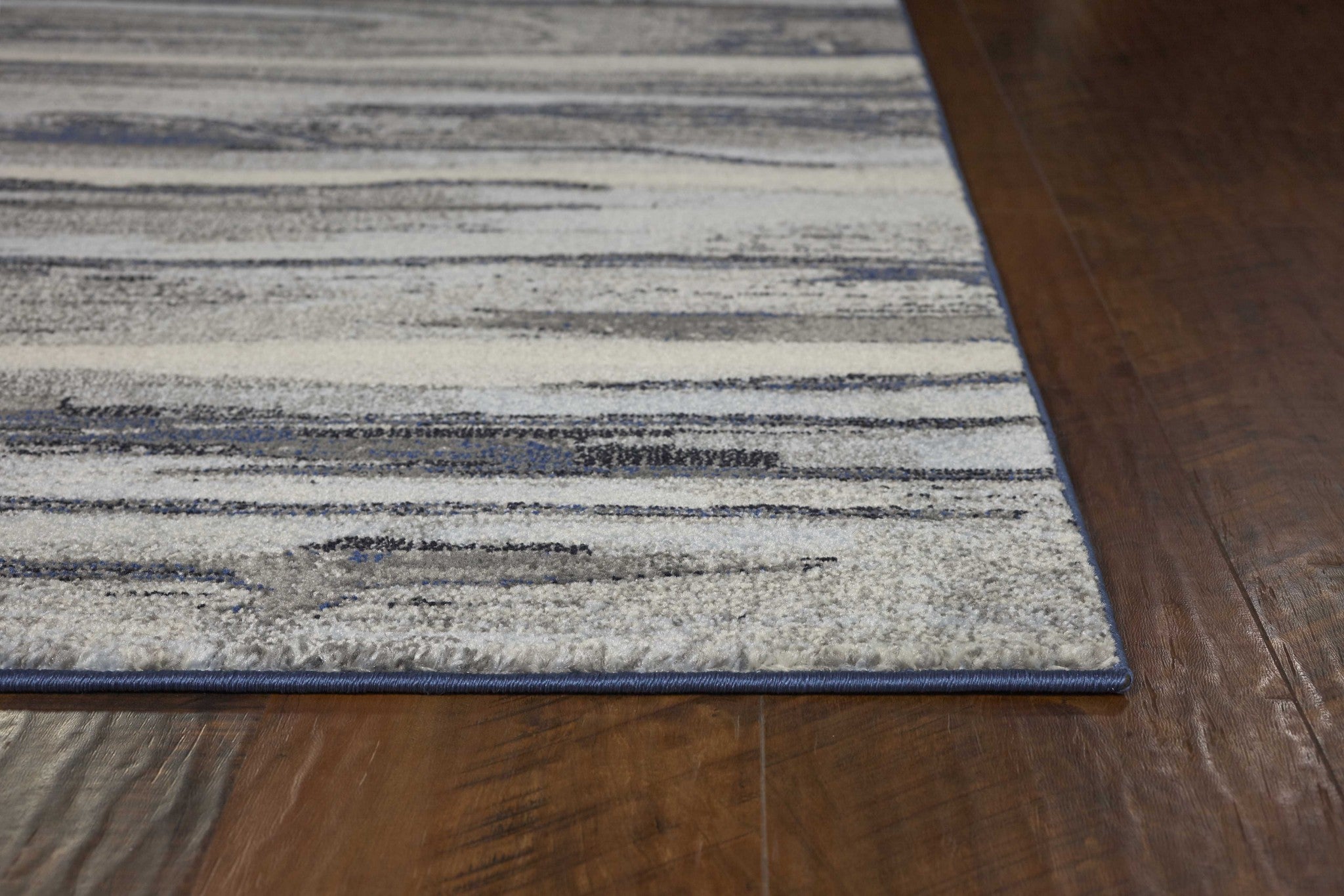 A stylish 8x11 grey abstract brushstroke indoor area rug, showcasing a modern watercolor design, perfect for contemporary home decor.