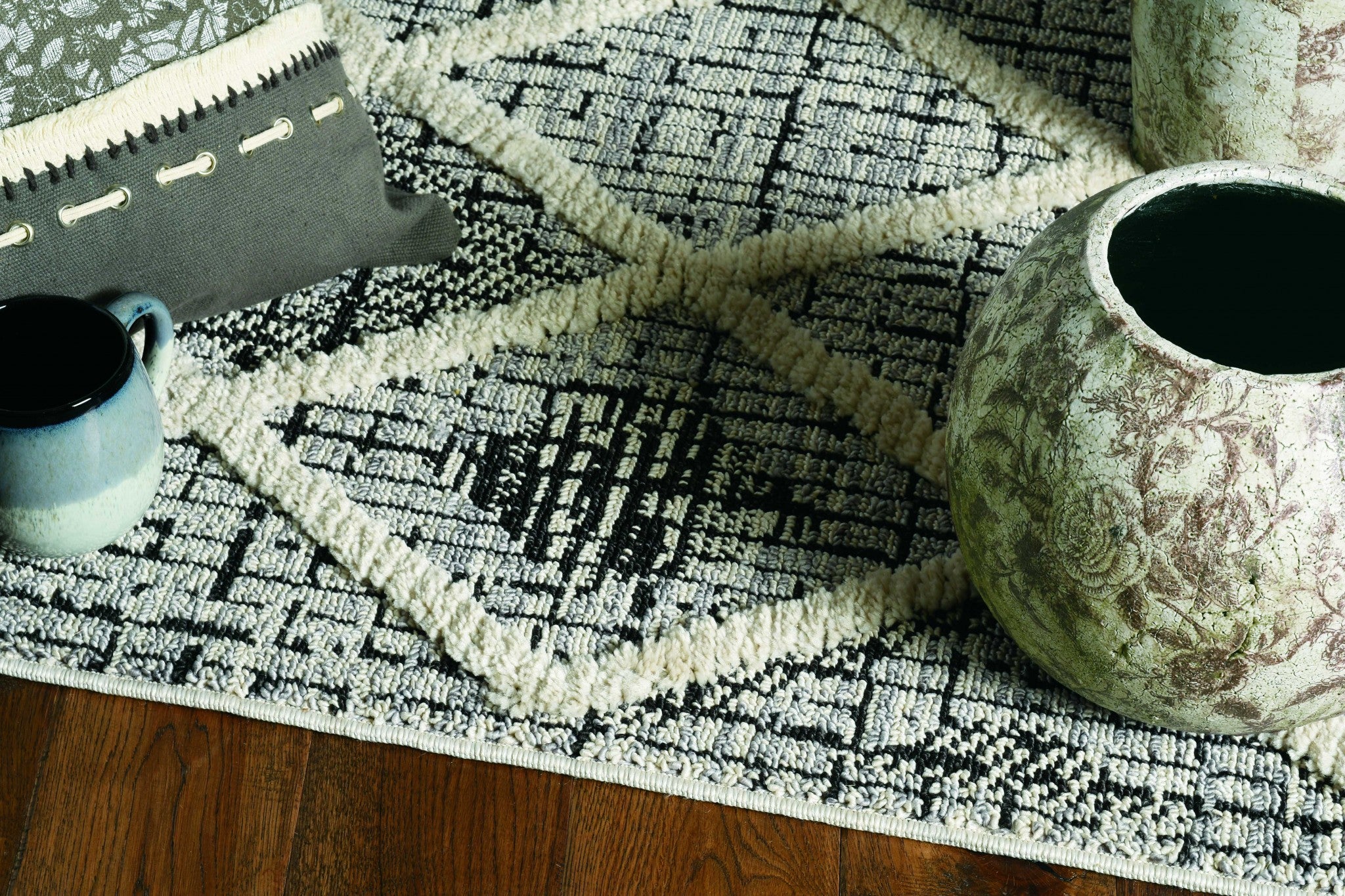 A stylish 94 x 130 charcoal polyester rug featuring a decorative cut loop pile and fringe, perfect for contemporary living spaces.