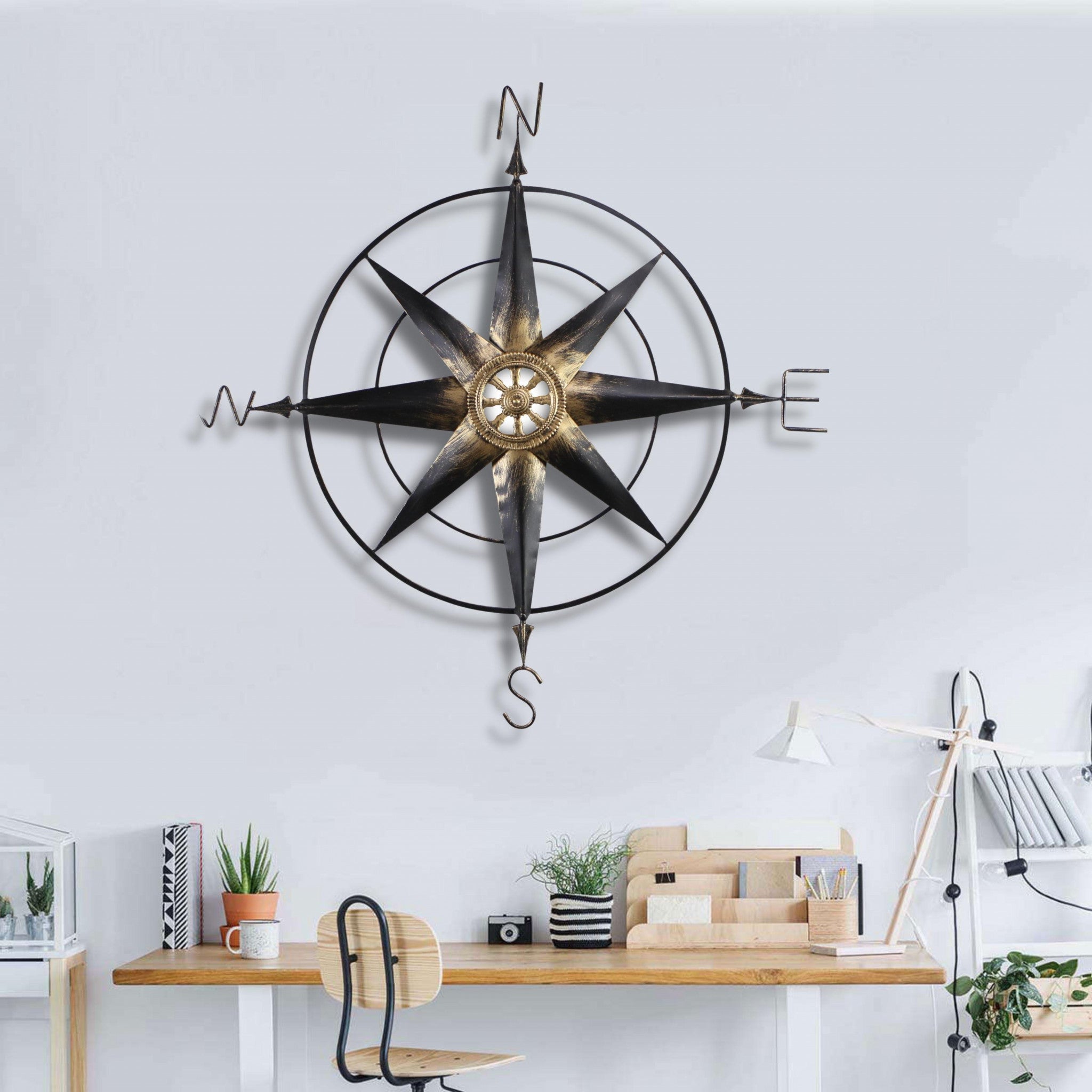 Black metal wall decor compass with gold center accents, showcasing a contemporary design and handcrafted details.