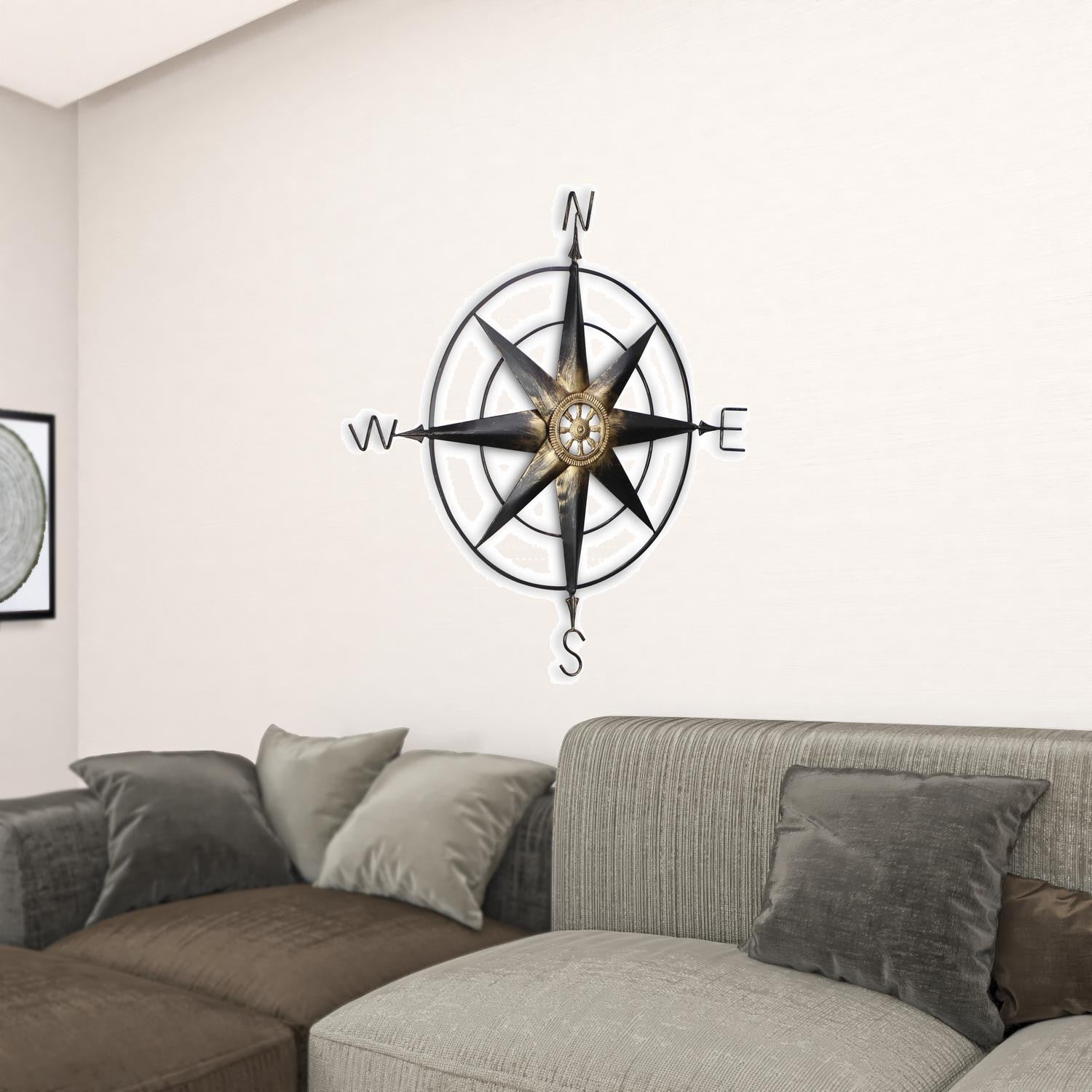 Black metal wall decor compass with gold center accents, showcasing a contemporary design and handcrafted details.