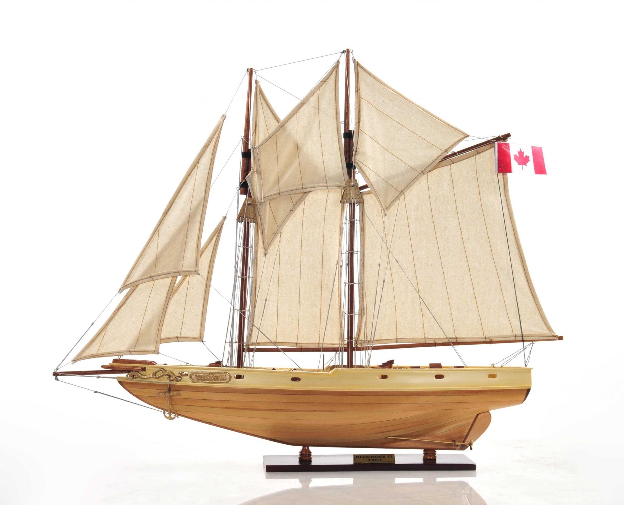 Bluenose model ship in light brown finish showcasing detailed rigging, lifeboats, and wooden craftsmanship.