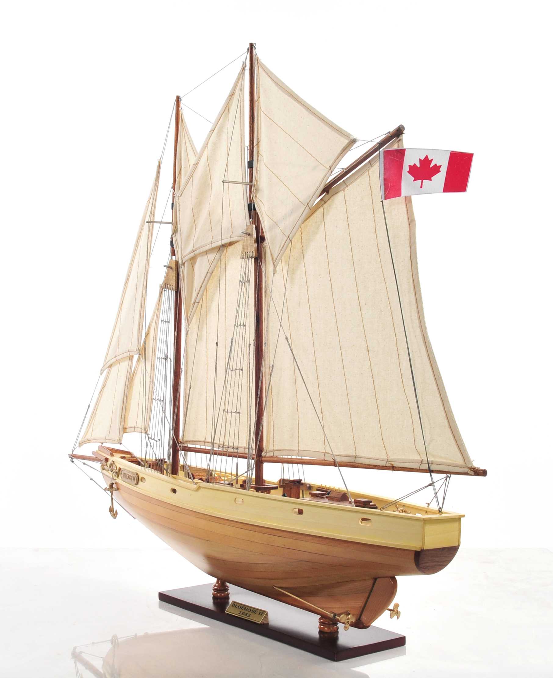 Bluenose model ship in light brown finish showcasing detailed rigging, lifeboats, and wooden craftsmanship.