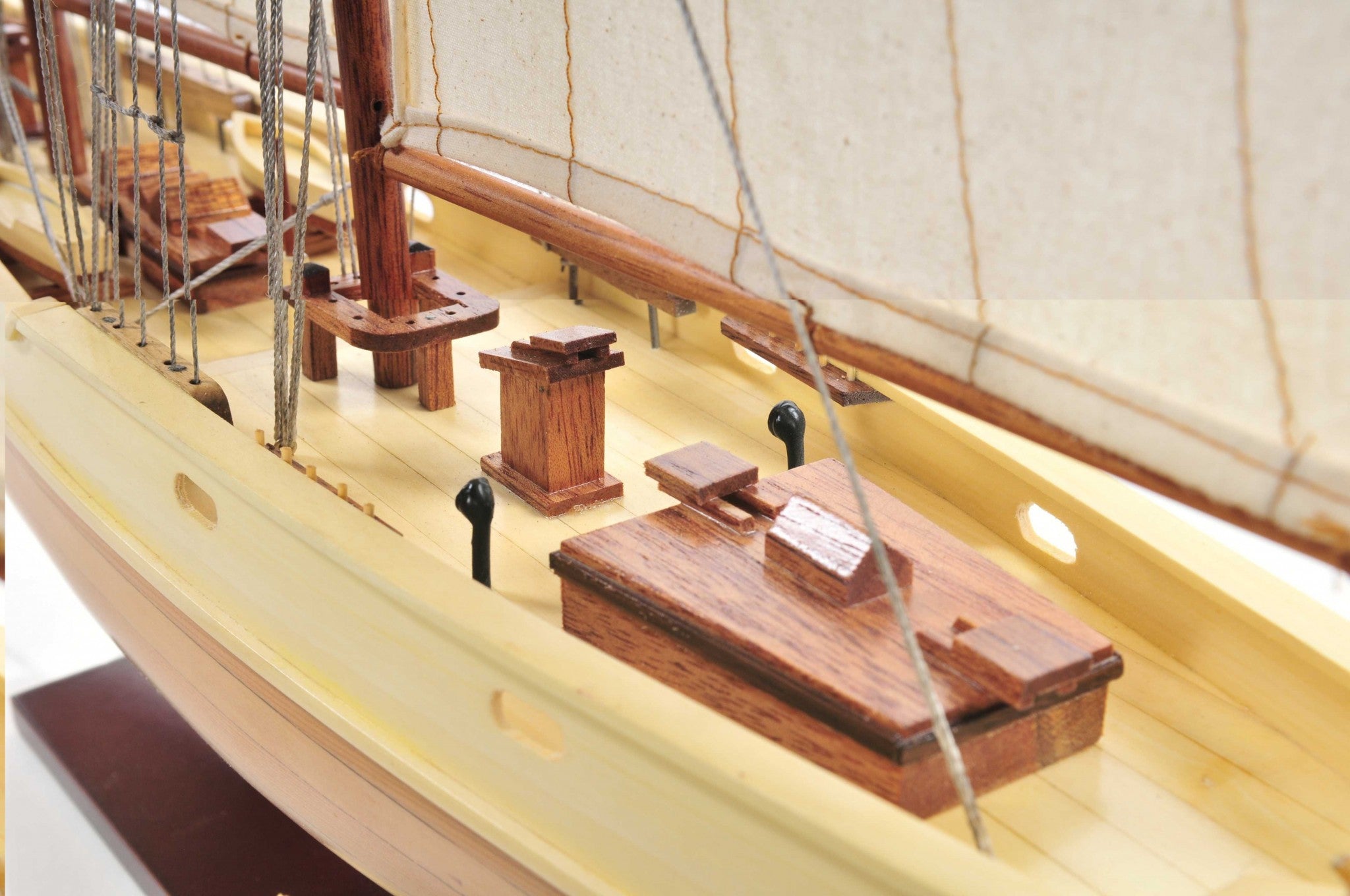 Bluenose model ship in light brown finish showcasing detailed rigging, lifeboats, and wooden craftsmanship.