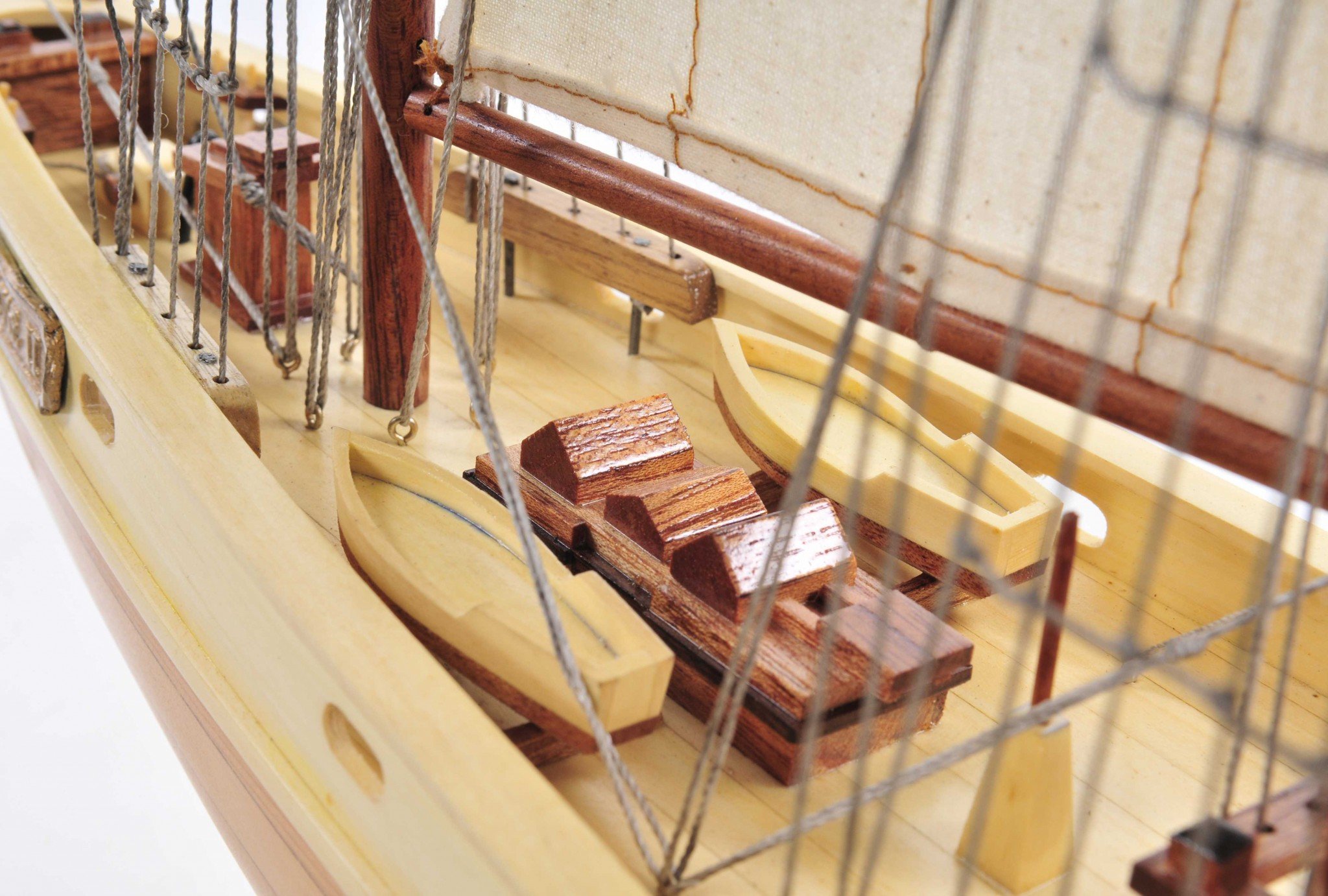 Bluenose model ship in light brown finish showcasing detailed rigging, lifeboats, and wooden craftsmanship.