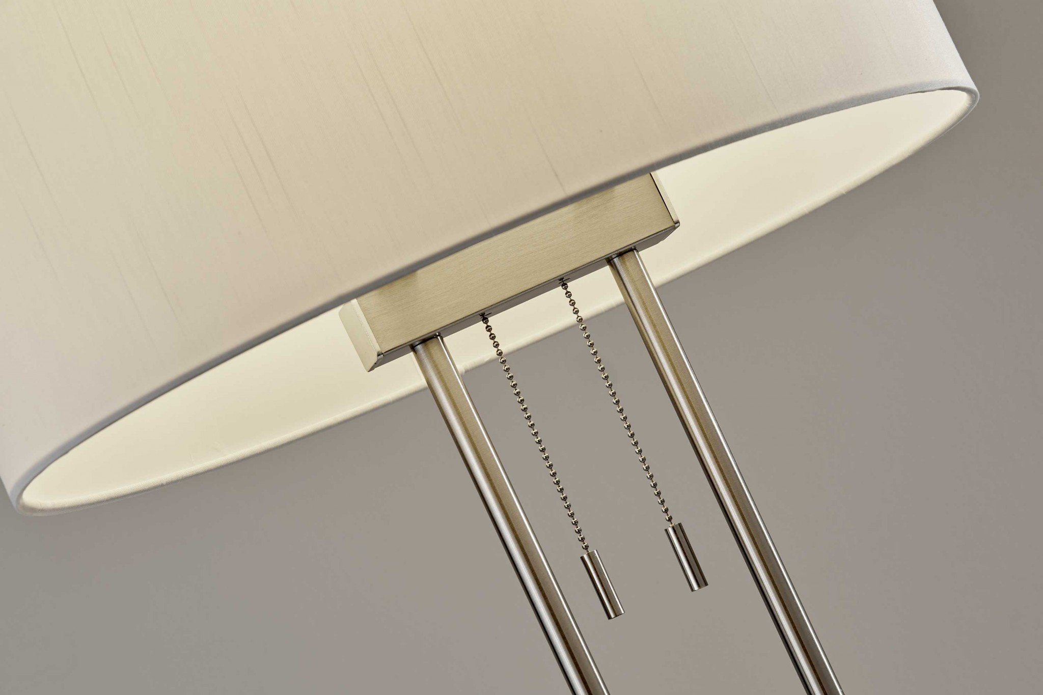 Brushed Steel Dual Pole Metal Table Lamp with off-white oval shade, showcasing modern design and dual pull chain switches.