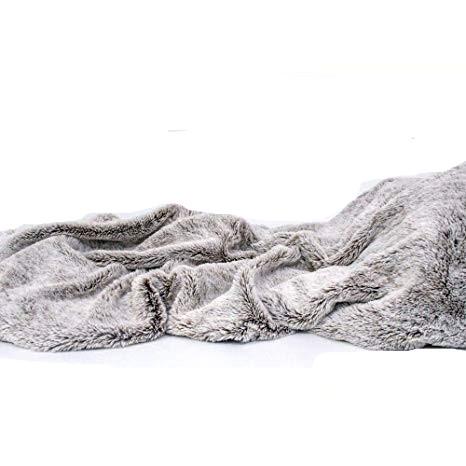 Cozy Gray Faux Fur Throw Blanket draped elegantly over a sofa, showcasing its luxurious texture and neutral color.