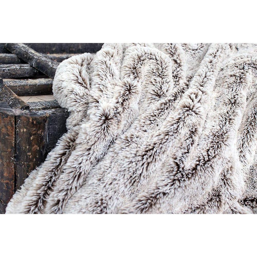 Cozy Gray Faux Fur Throw Blanket draped elegantly over a sofa, showcasing its luxurious texture and neutral color.