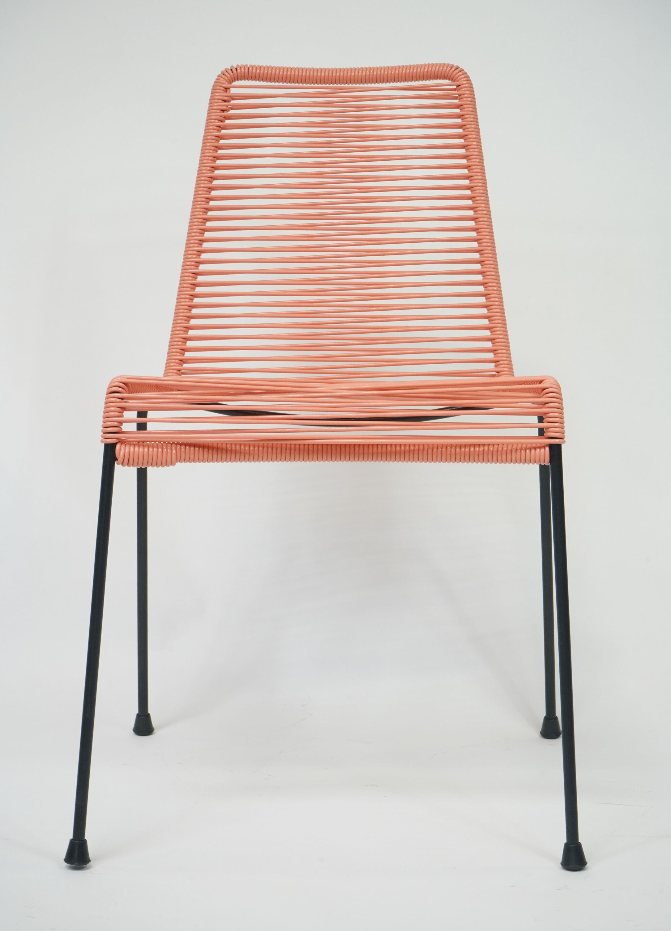 El Durazno Chair in peach and black, showcasing its stylish design and inviting curves.