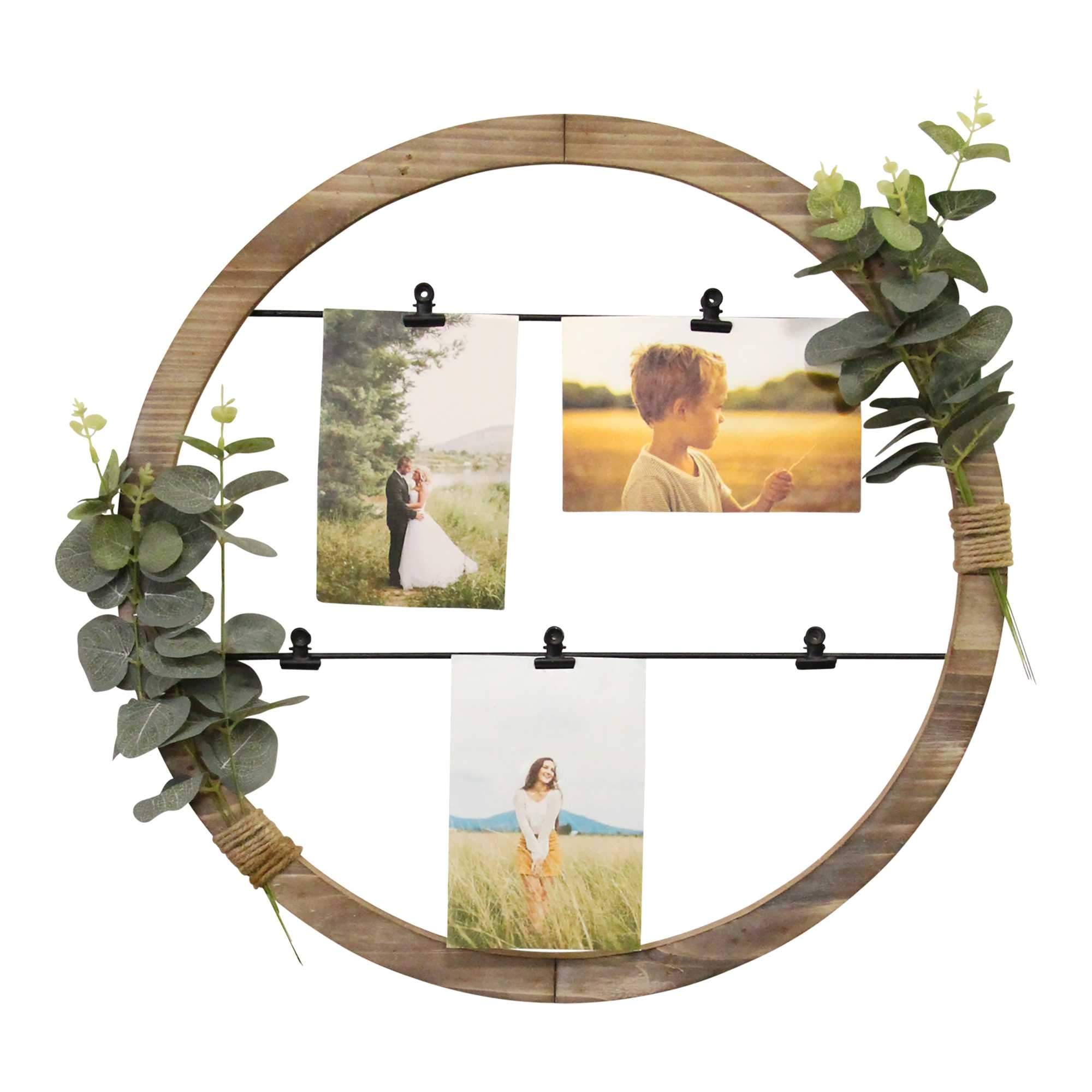 Eucalyptus Photo Holder Wall Art featuring a distressed white wood frame with decorative eucalyptus and five black metal clips for photos.