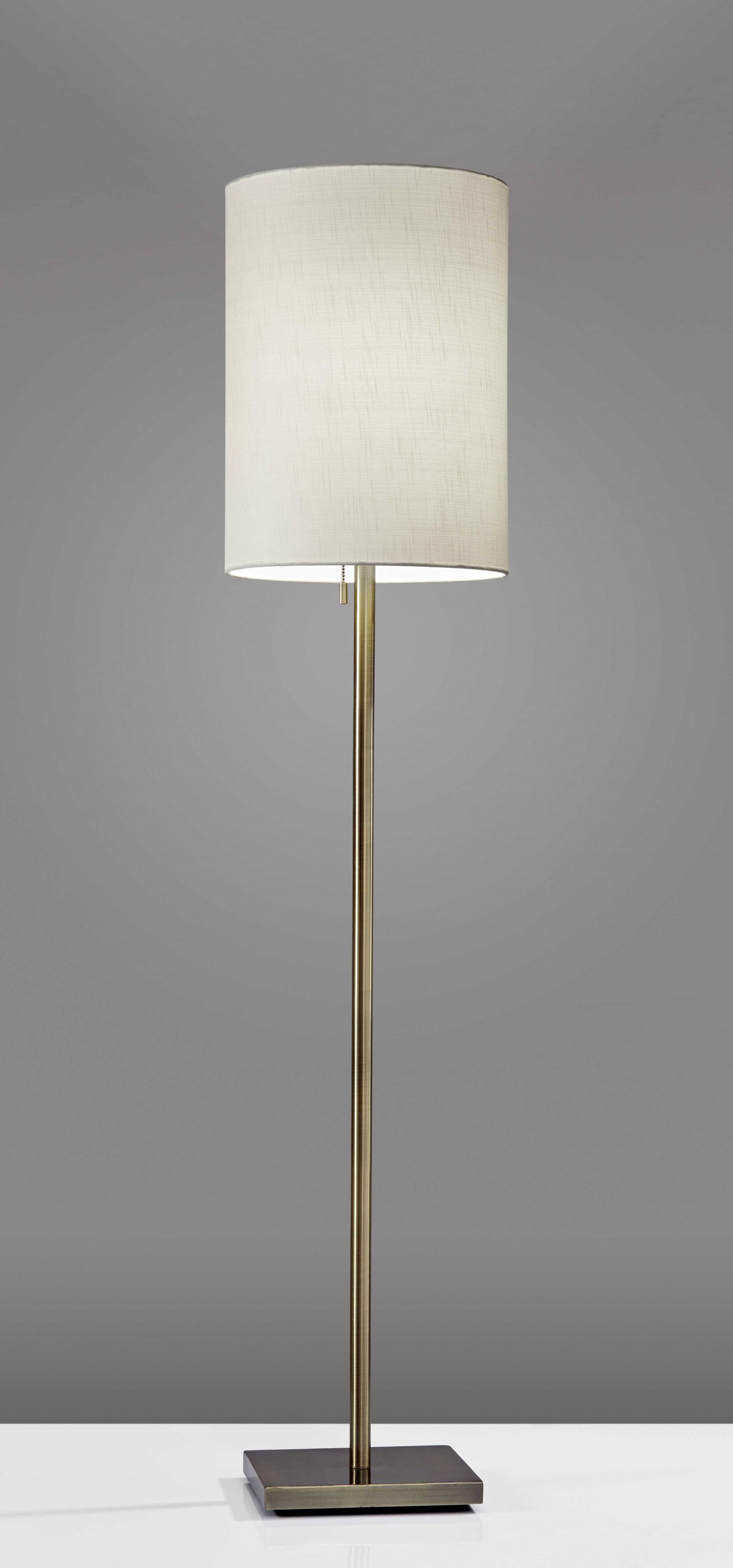 Elegant floor lamp with brushed steel metal pole and light beige textured fabric shade, featuring a compact square base.