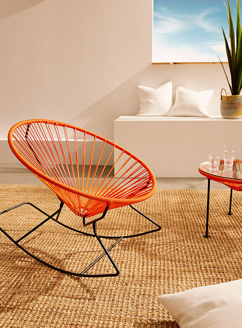 Innit Rocking Chair featuring a modern design with a round profile, made of durable powder-coated steel and colorful woven vinyl cord.