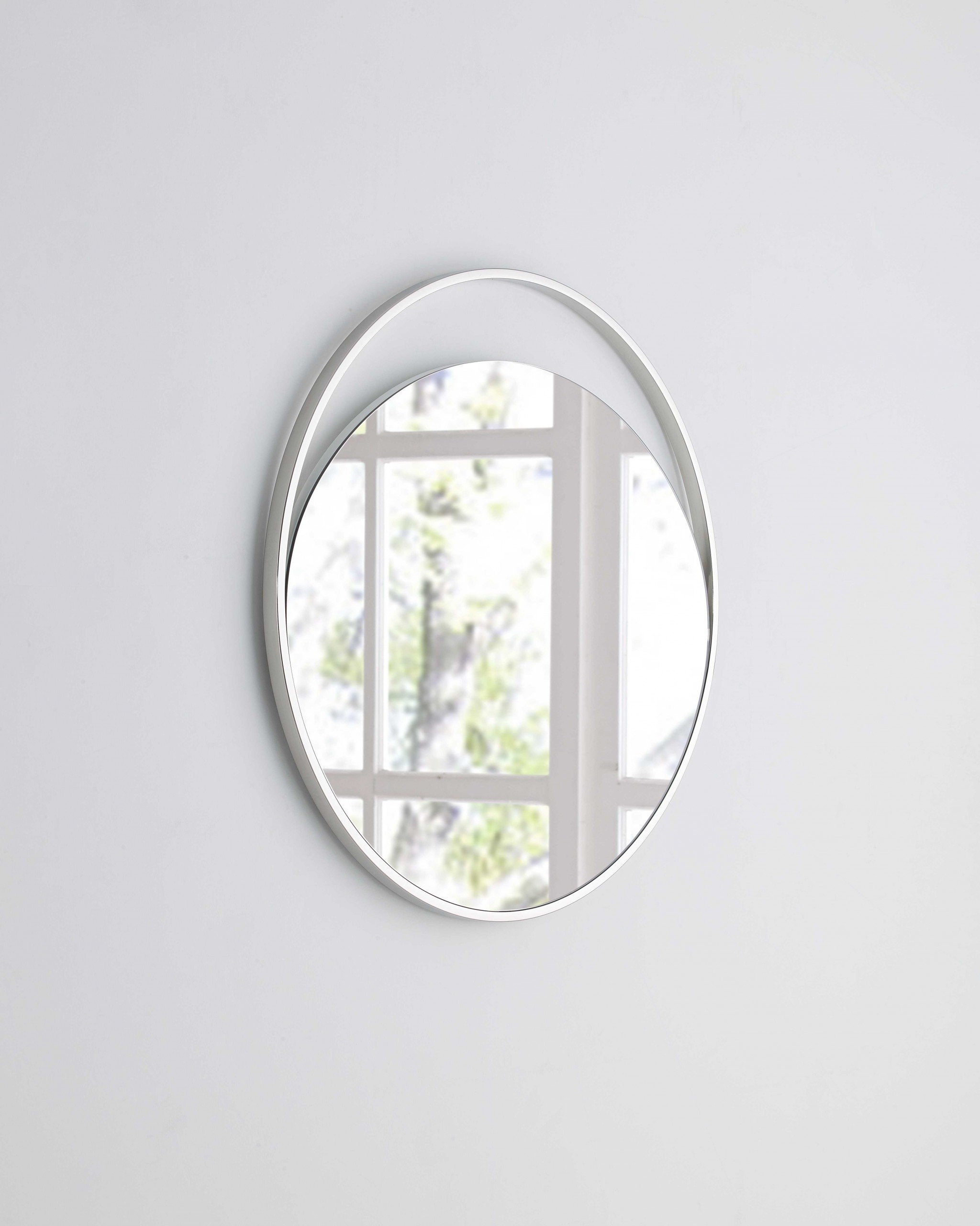 Medium round mirror with a matte white finish and polished stainless steel frame, showcasing a modern and elegant design.