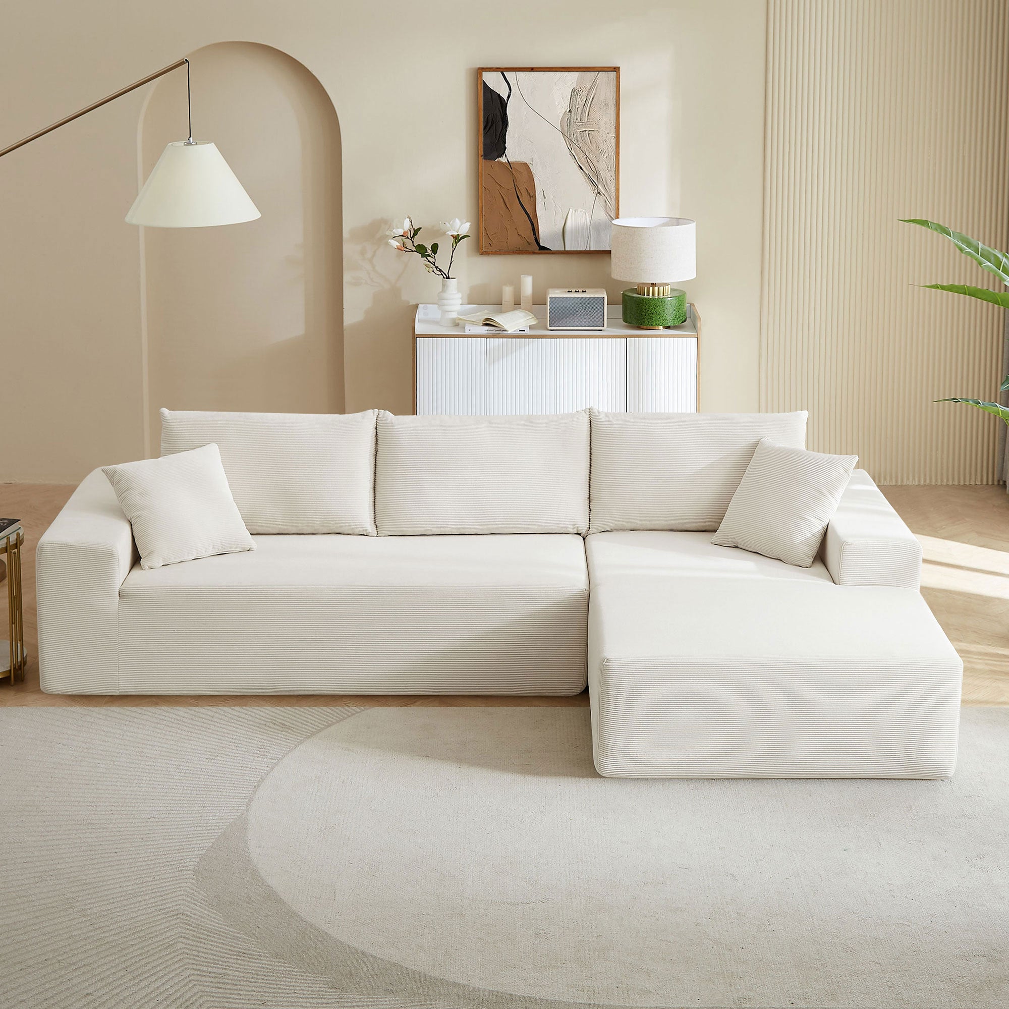 A modern modular sectional living room sofa set in beige upholstery, featuring a chaise lounge and plush cushions, perfect for stylish and comfortable living spaces.