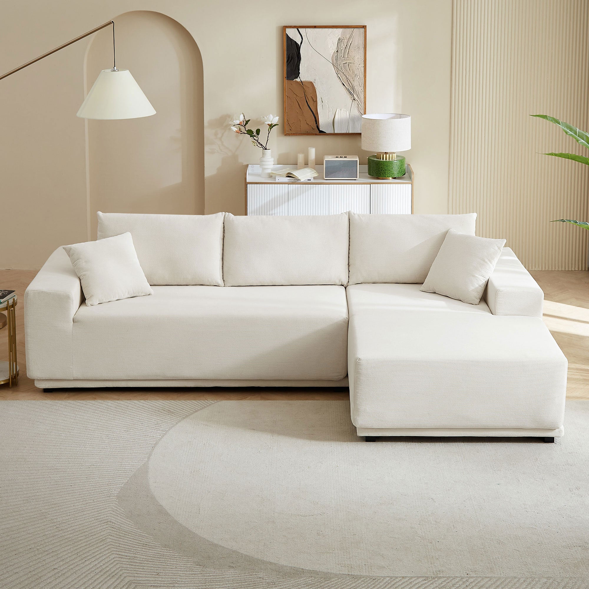 A modern modular sectional living room sofa set in beige upholstery, featuring a chaise lounge and plush cushions, perfect for stylish and comfortable living spaces.