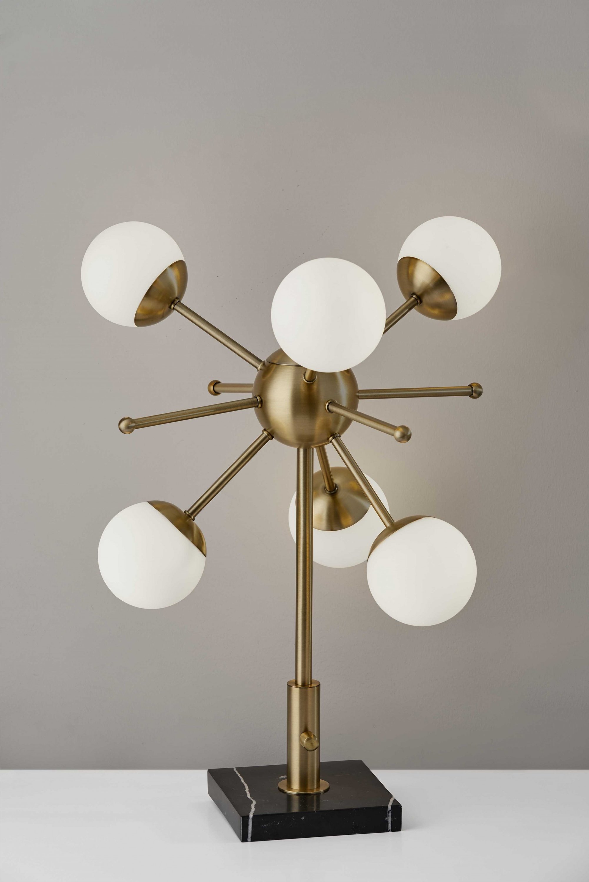 Orbital Sphere Brass LED Table Lamp with six opal glass globes and antique brass finish on a black marble base.