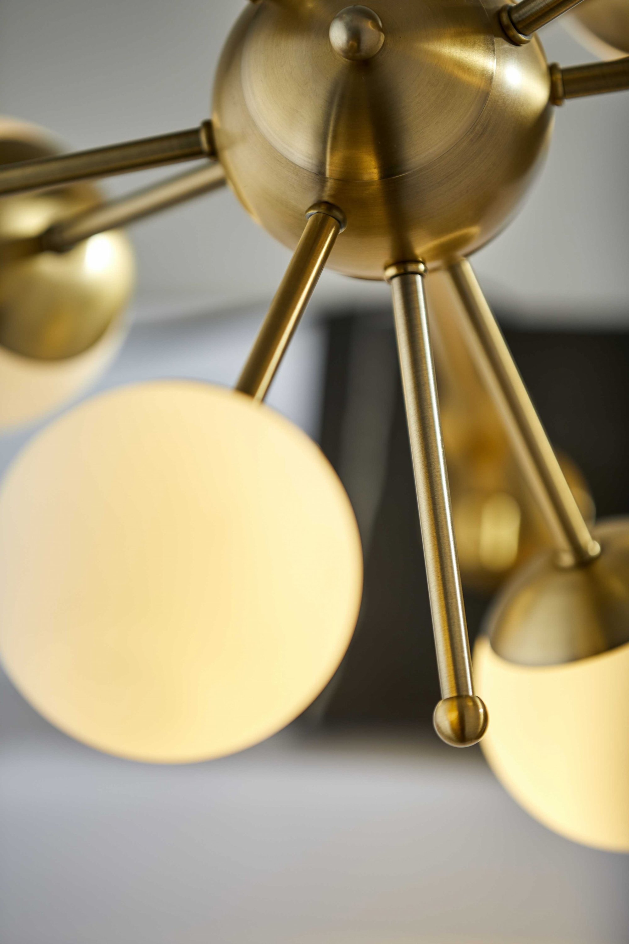 Orbital Sphere Brass LED Table Lamp with six opal glass globes and antique brass finish on a black marble base.