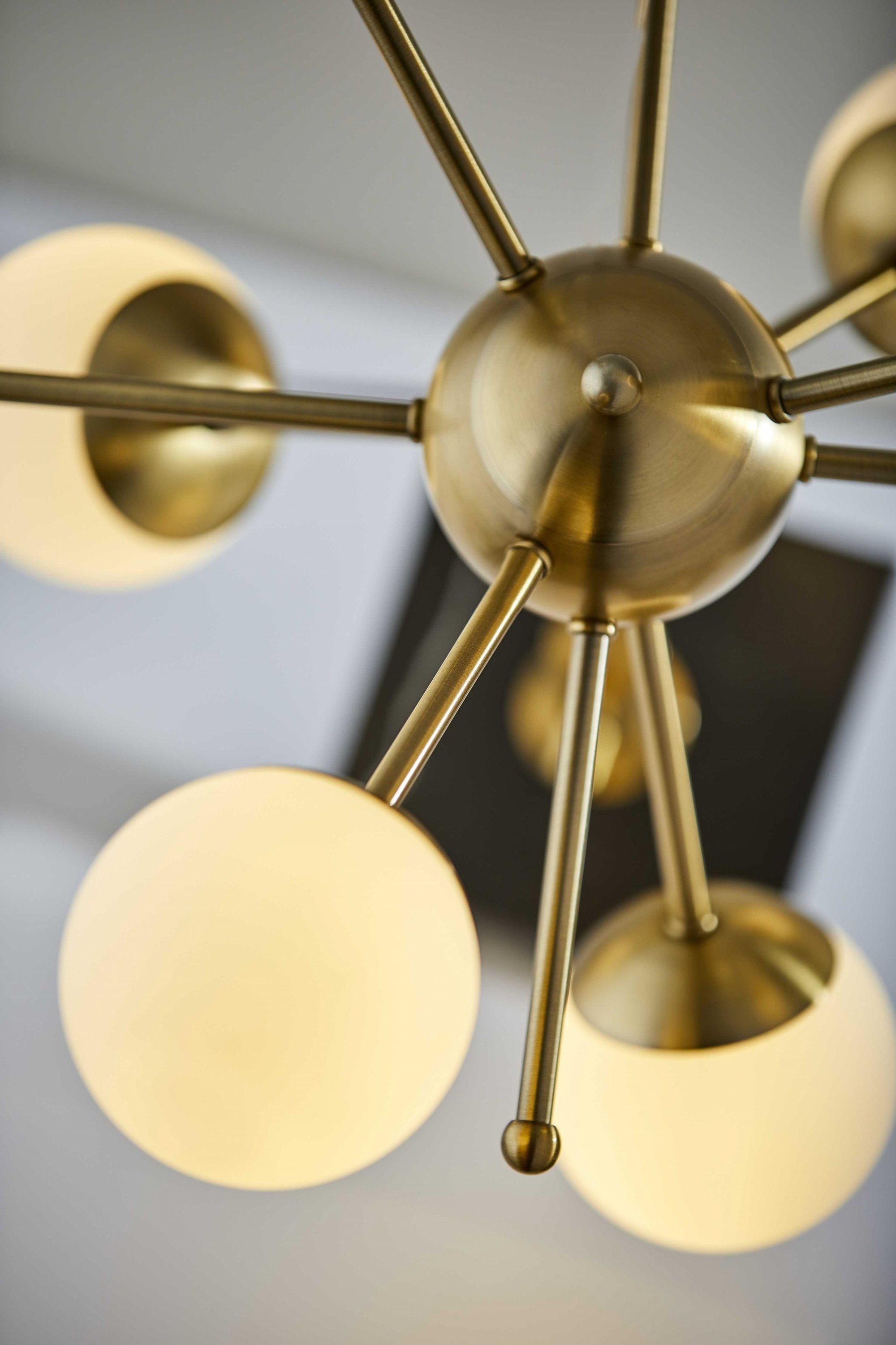 Orbital Sphere Brass LED Table Lamp with six opal glass globes and antique brass finish on a black marble base.