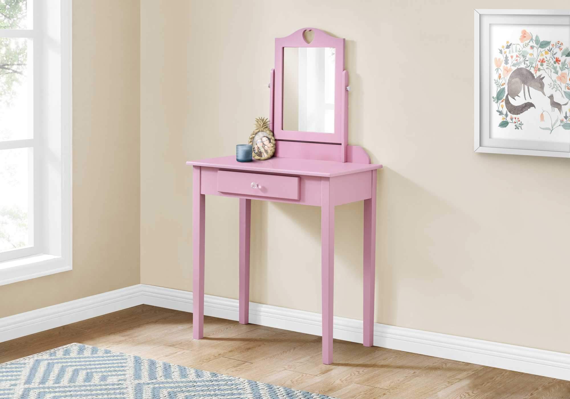 A stylish pink vanity mirror with a storage drawer, featuring a heart cut-out design and a crystal knob, perfect for a girl's bedroom.