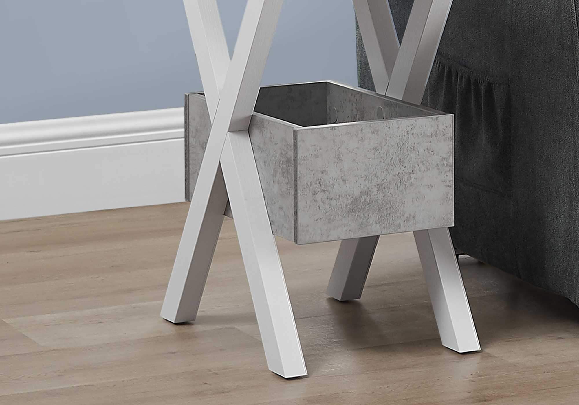 Rectangular accent table with white cross legs and grey cement look finish, perfect for modern decor.